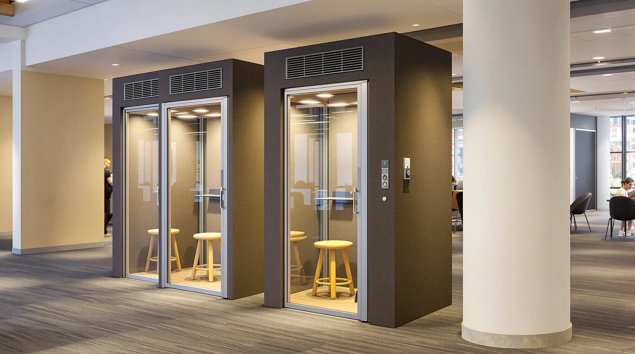 A row of freestanding acoustic phone booths on an open office floor in the evening