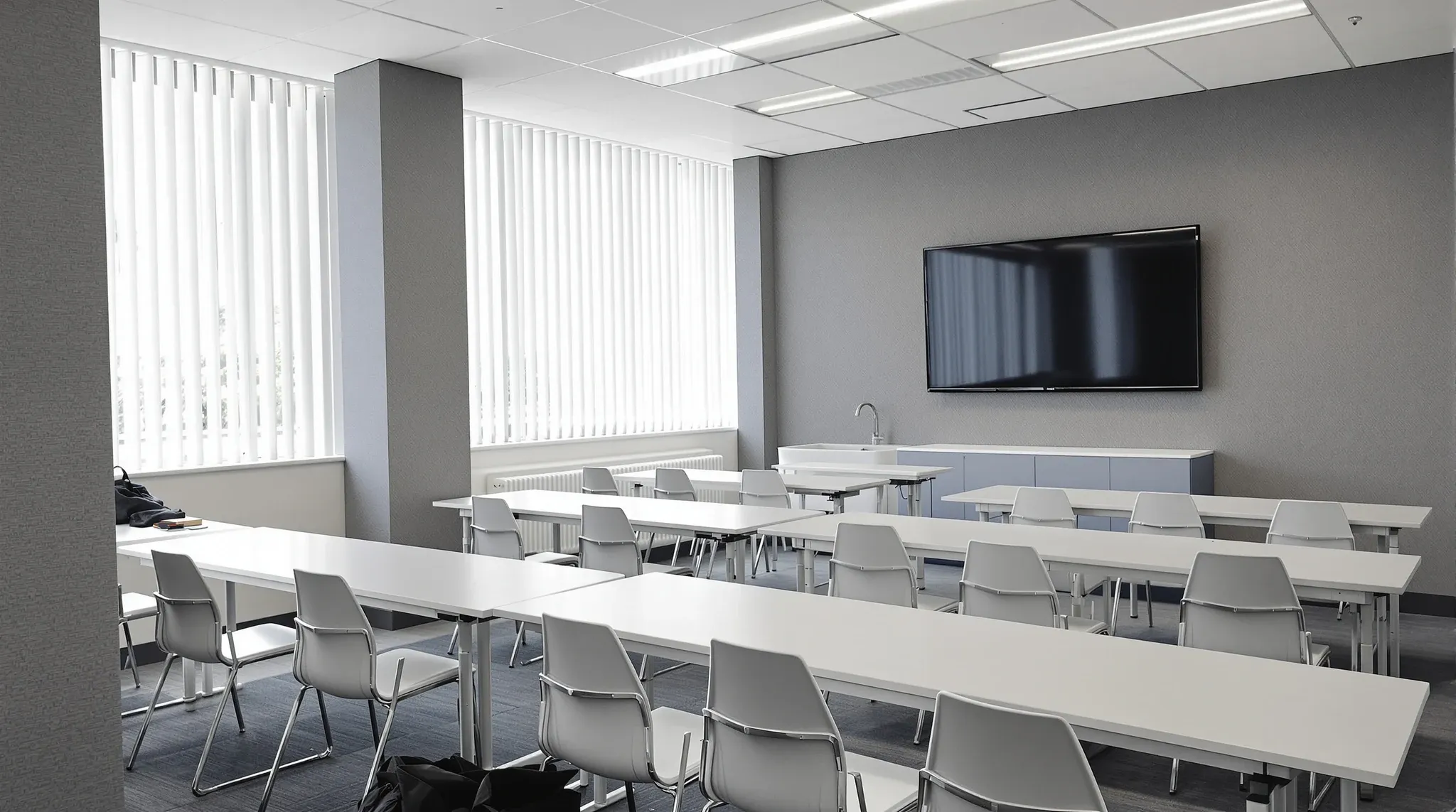 A fitted-out training room in a suburban office building with rows of tables and acoustic wall panels