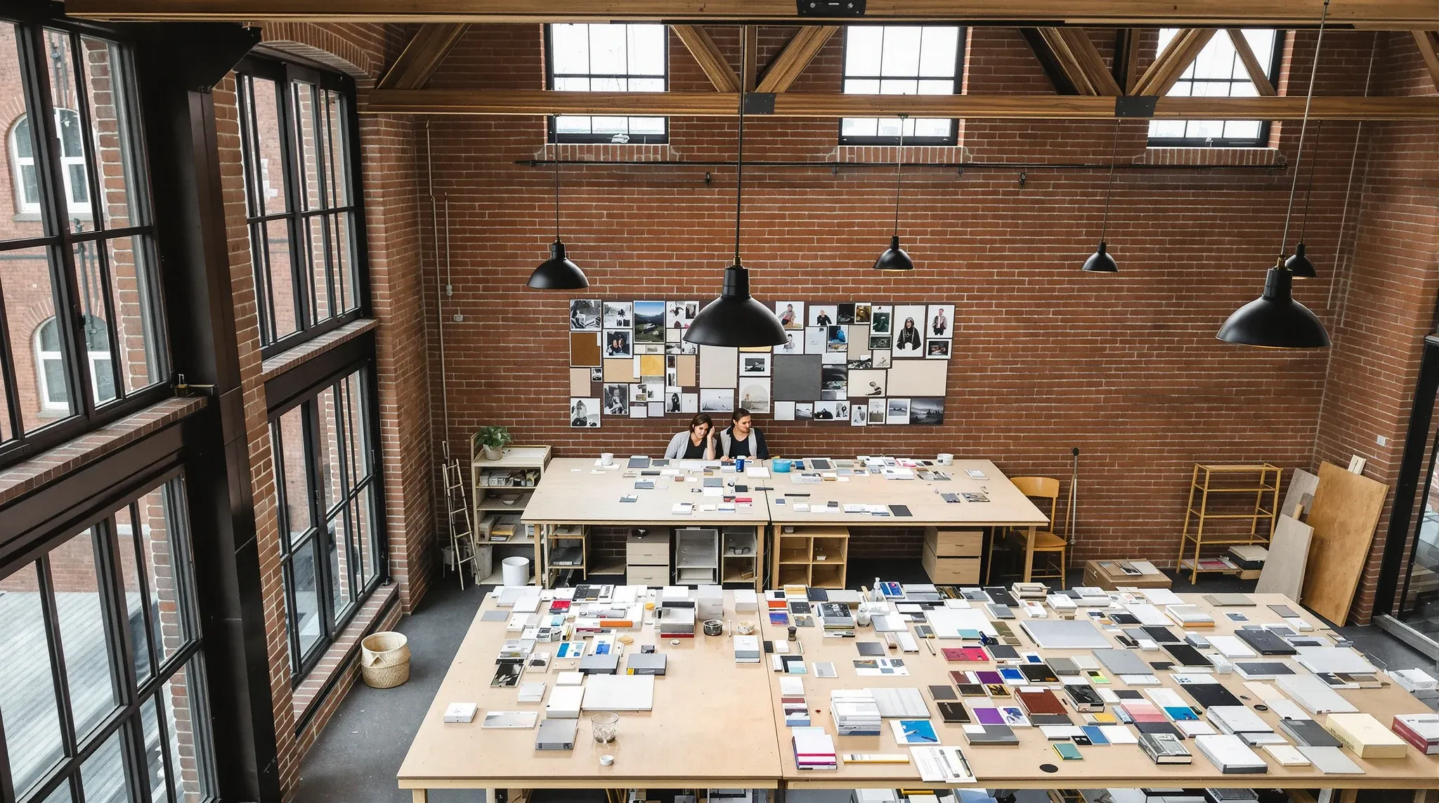A creative studio in a converted brick warehouse with large shared worktables