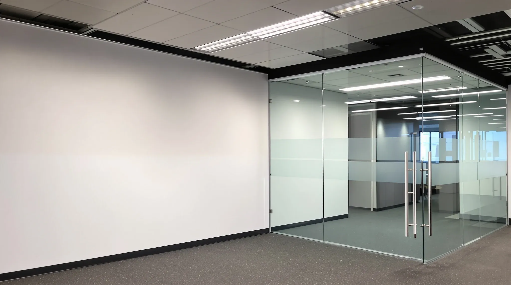 Empty office showing a half-height screen, a full-height plasterboard wall and a glass wall together