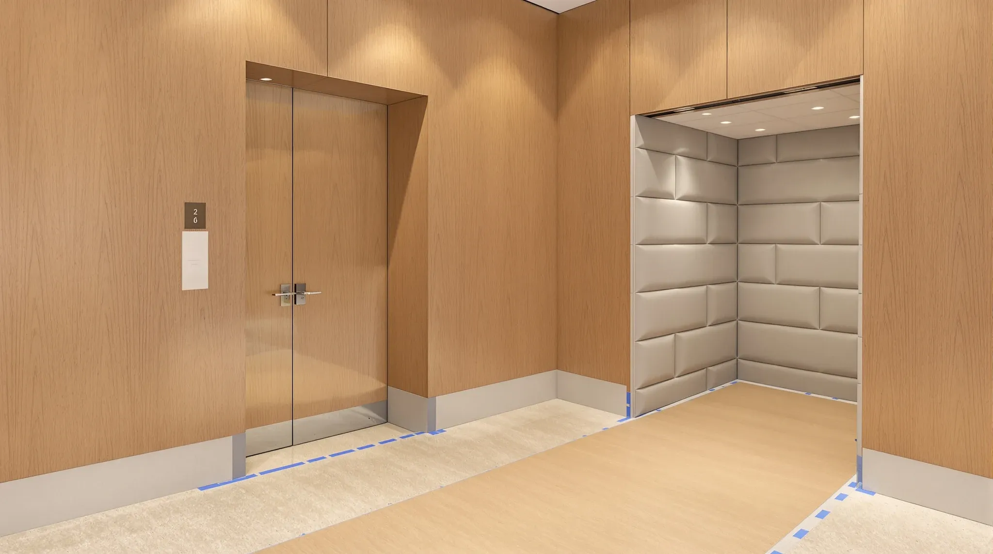 A shared lift lobby with its stone floor and wall corners protected during office fitout works