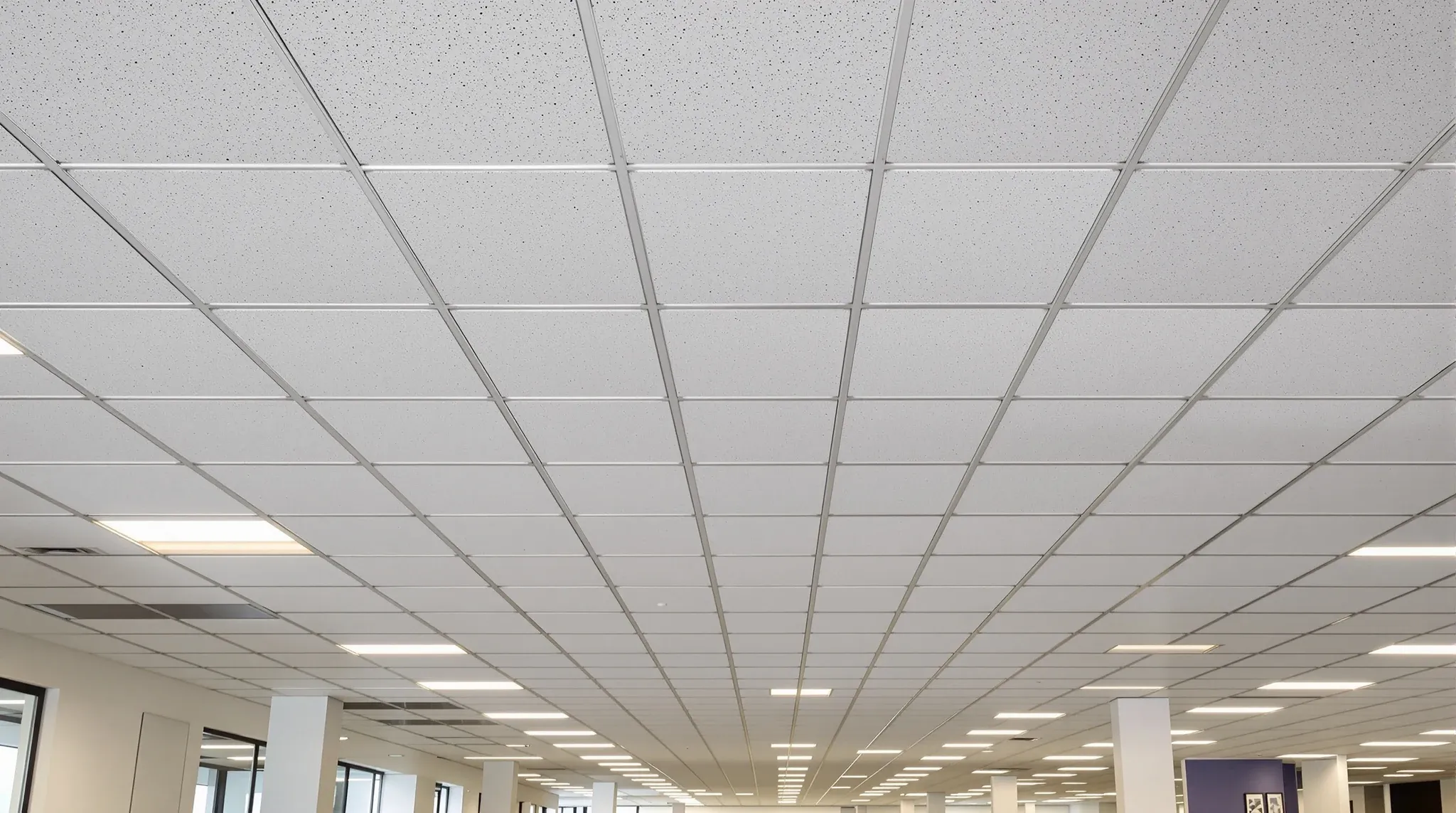 A wide view of a finished office ceiling with a consistent exposed T bar grid