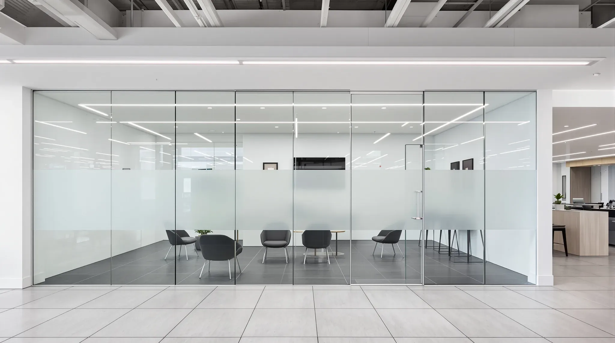 Frameless glass sales office with a frosted band and a glass door on a tiled car showroom floor