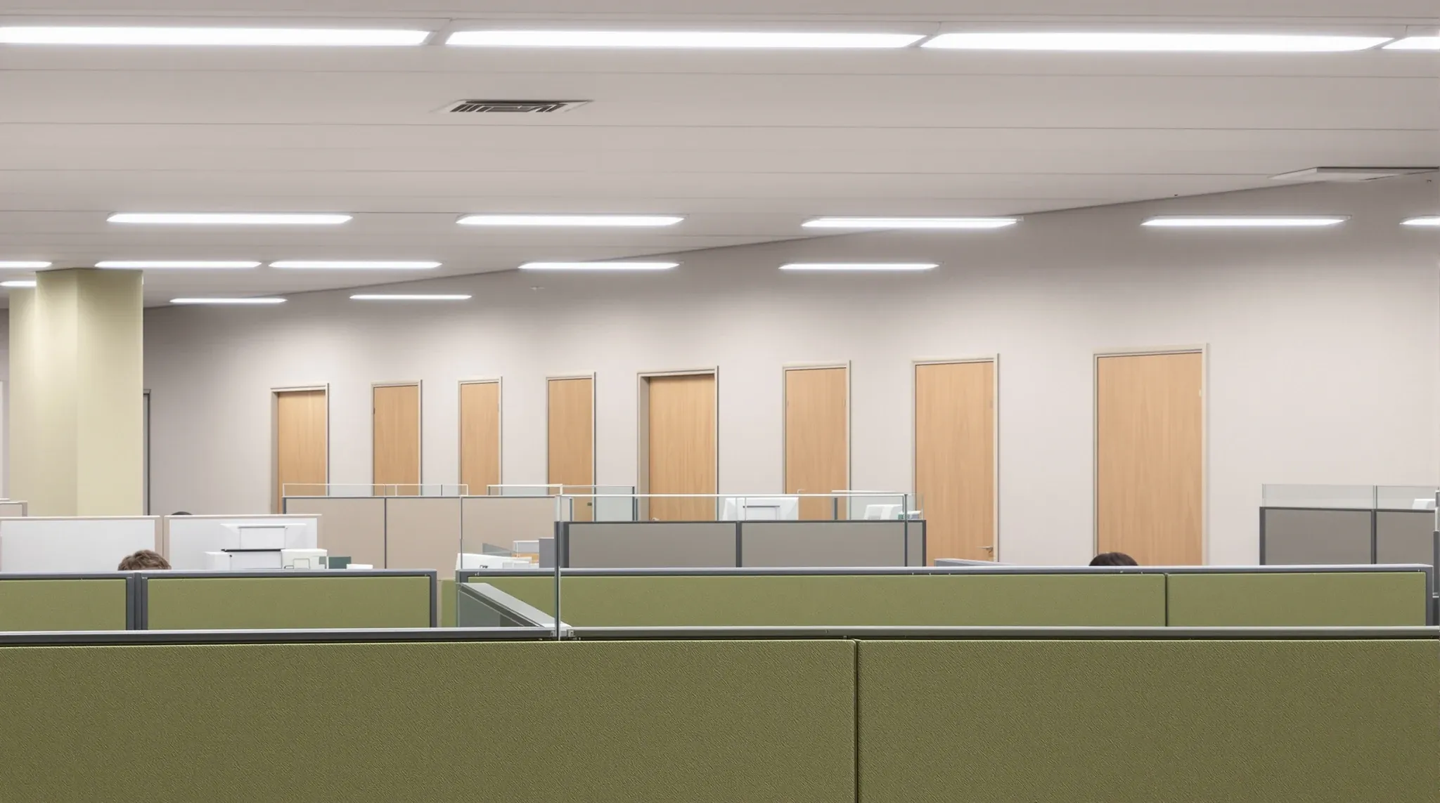 Partial-height screens around a team area with full-height enclosed rooms along the back wall
