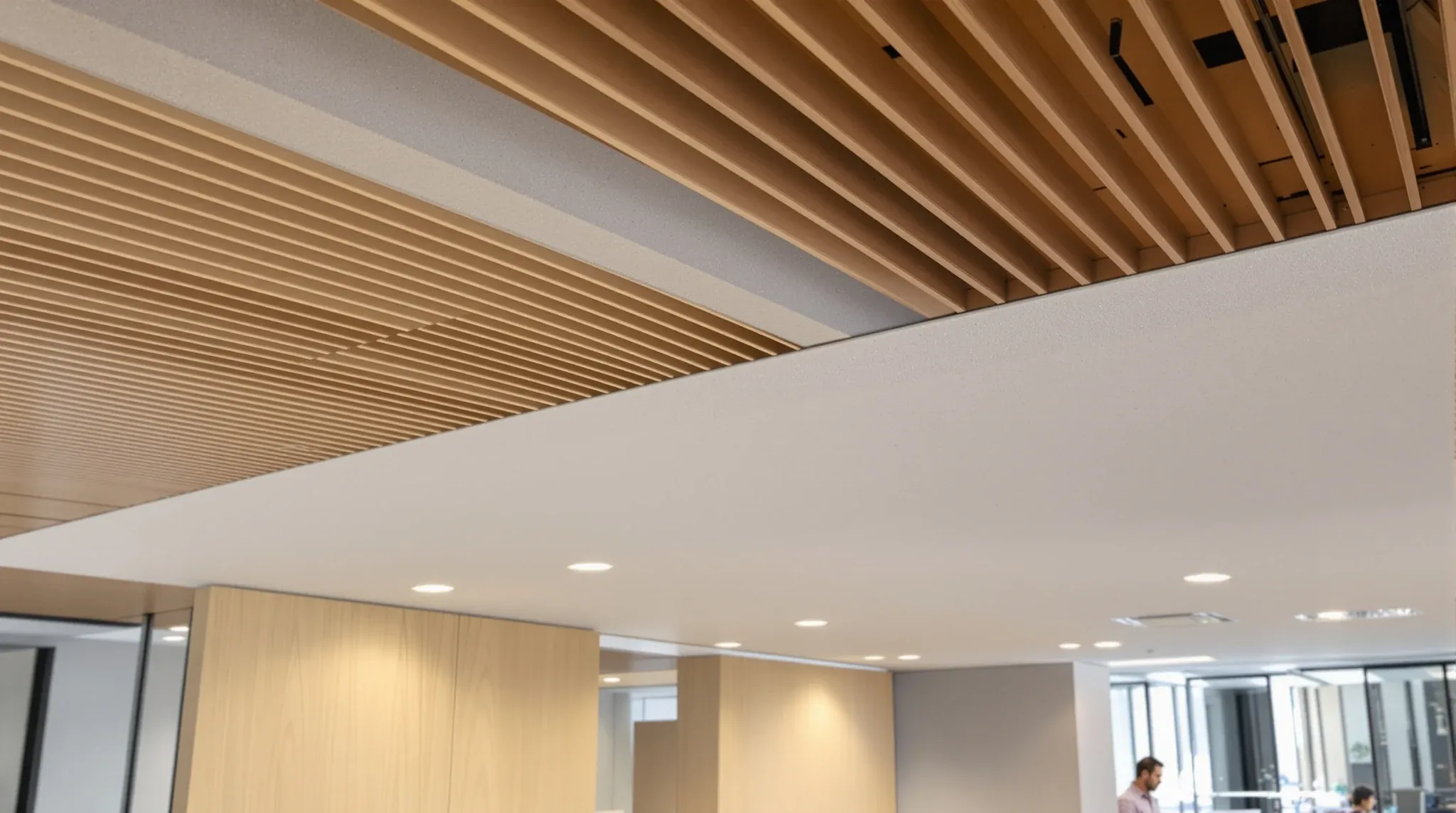 A plasterboard bulkhead marking a lower ceiling zone above an office kitchenette