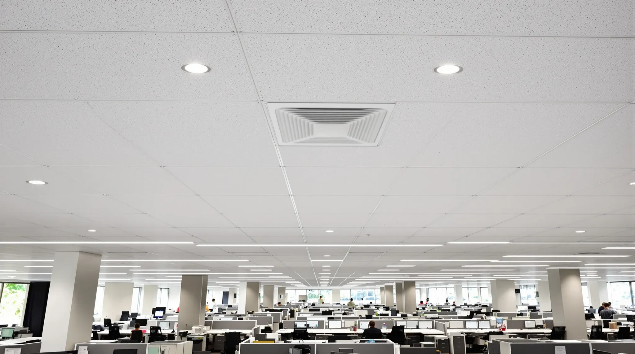 A finished open plan office ceiling grid with a flush access panel and downlights
