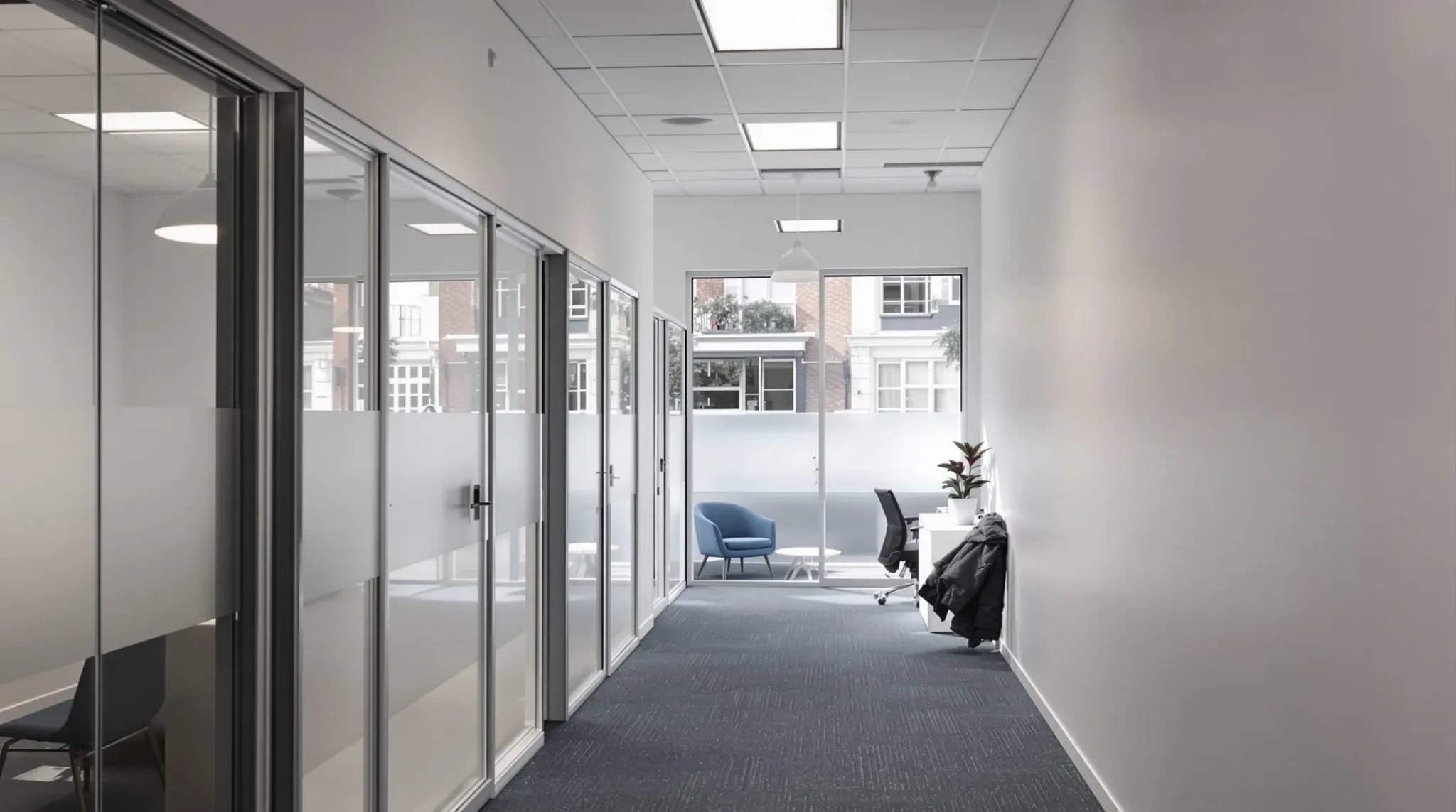 Narrow former shop converted to an office, with frosted band on the shopfront glass and glass offices along one wall