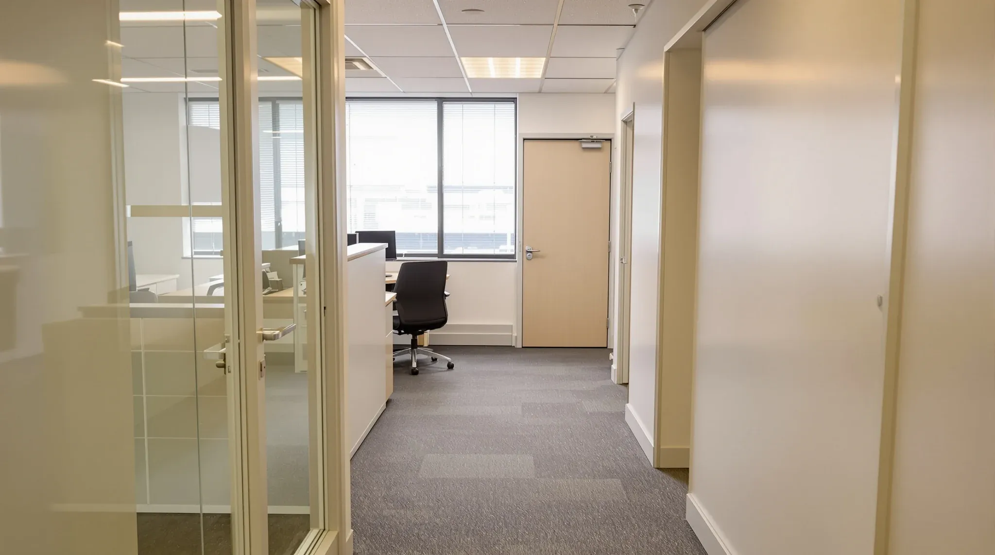 The interior of a small shared entry office suite with blinds lowered