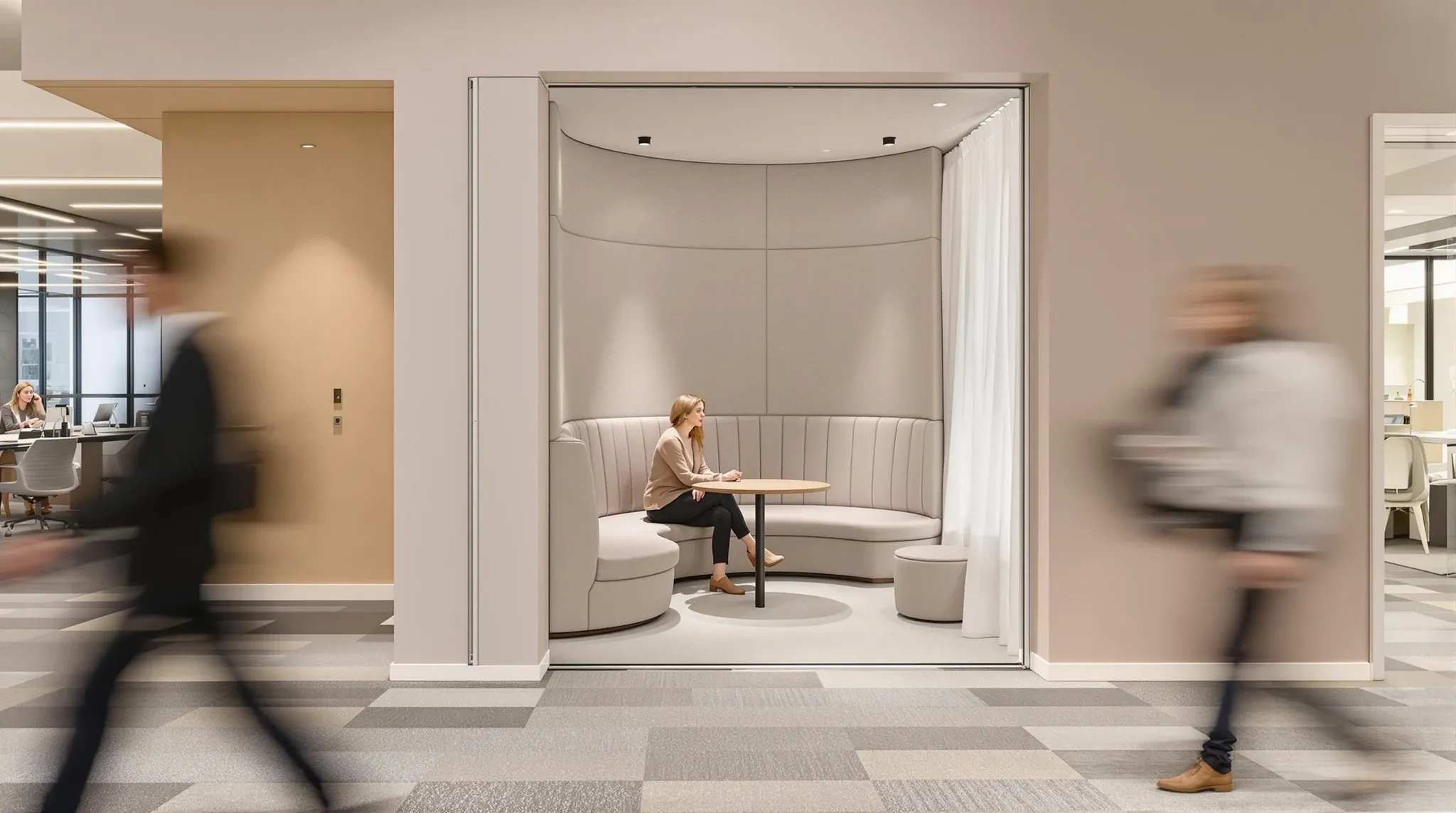 A muted, low-light work alcove at the far side of a busy office floor