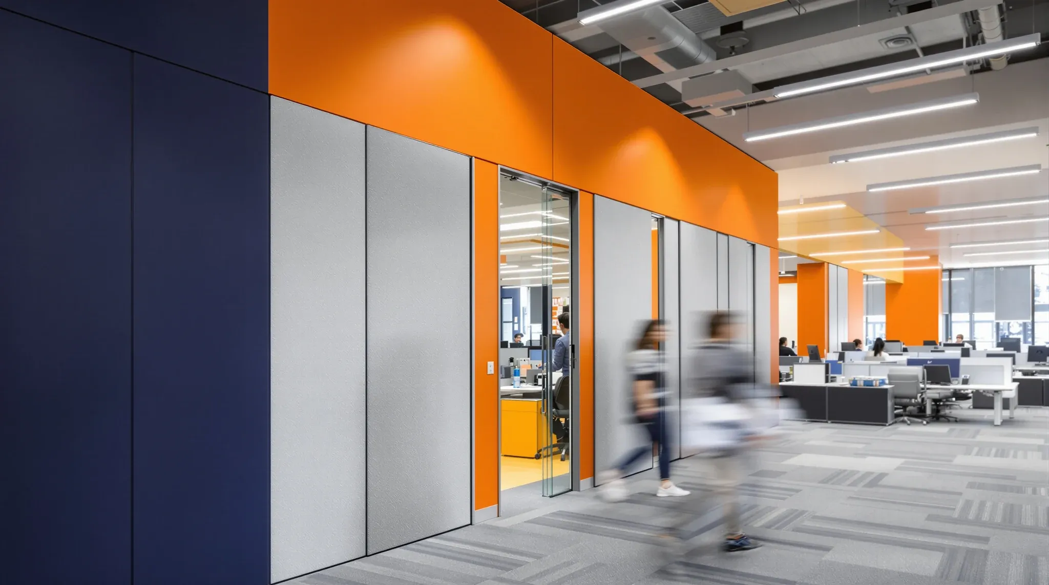 A busy sales floor bounded by a solid navy wall and a manager office