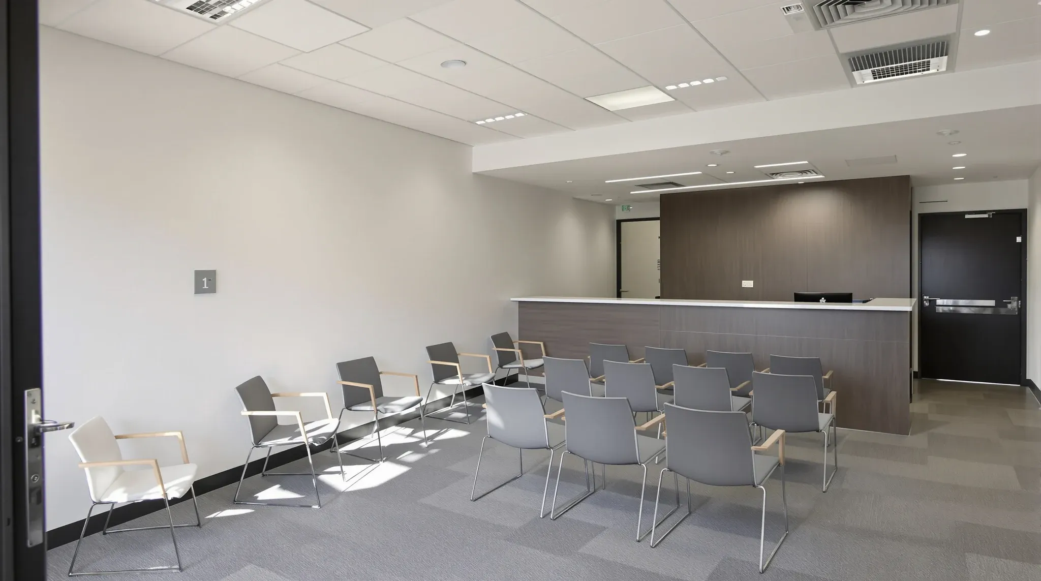Finished empty clinic waiting room with rows of chairs, reception counter edge, soft lighting