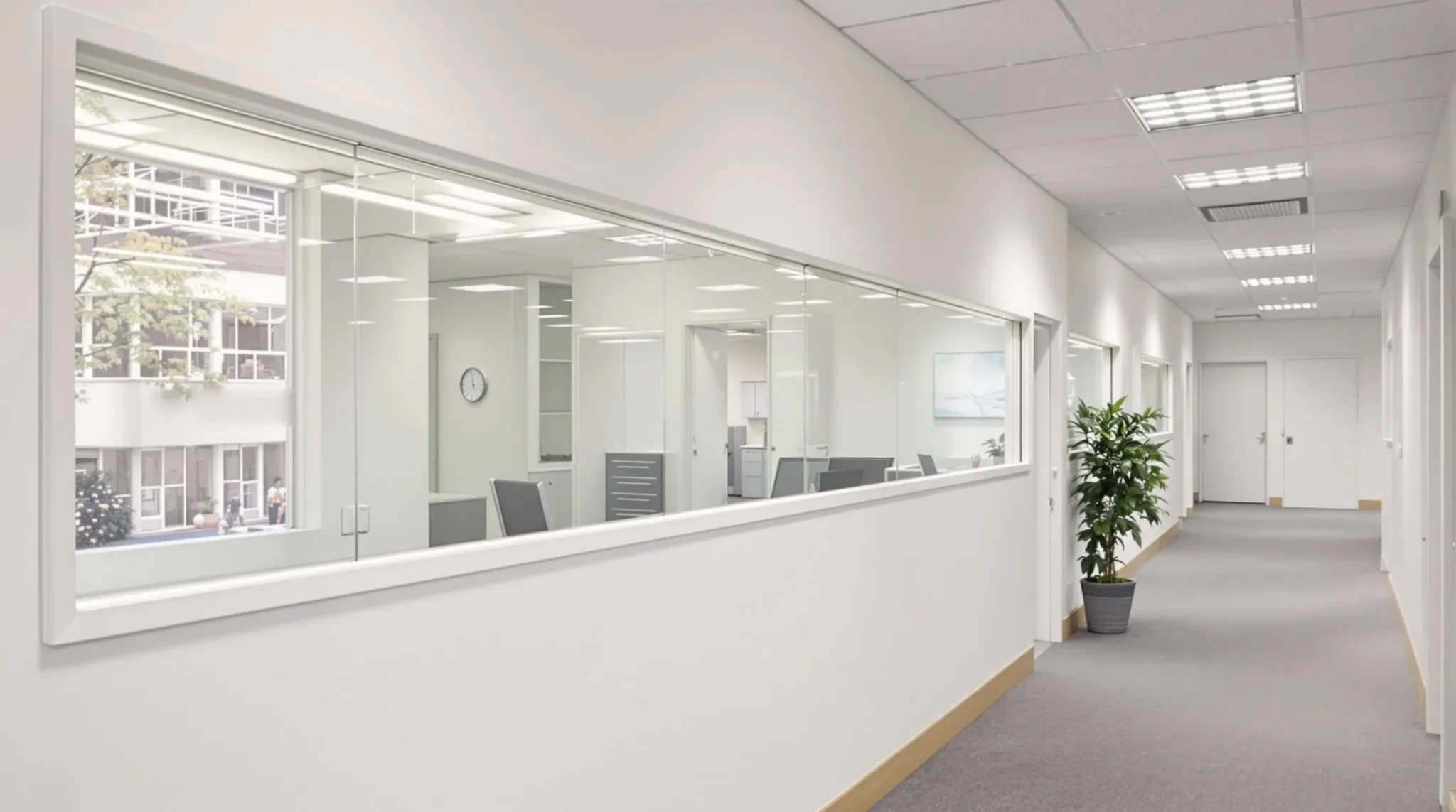 A plasterboard office wall with a strip of clear glass along the top to borrow daylight