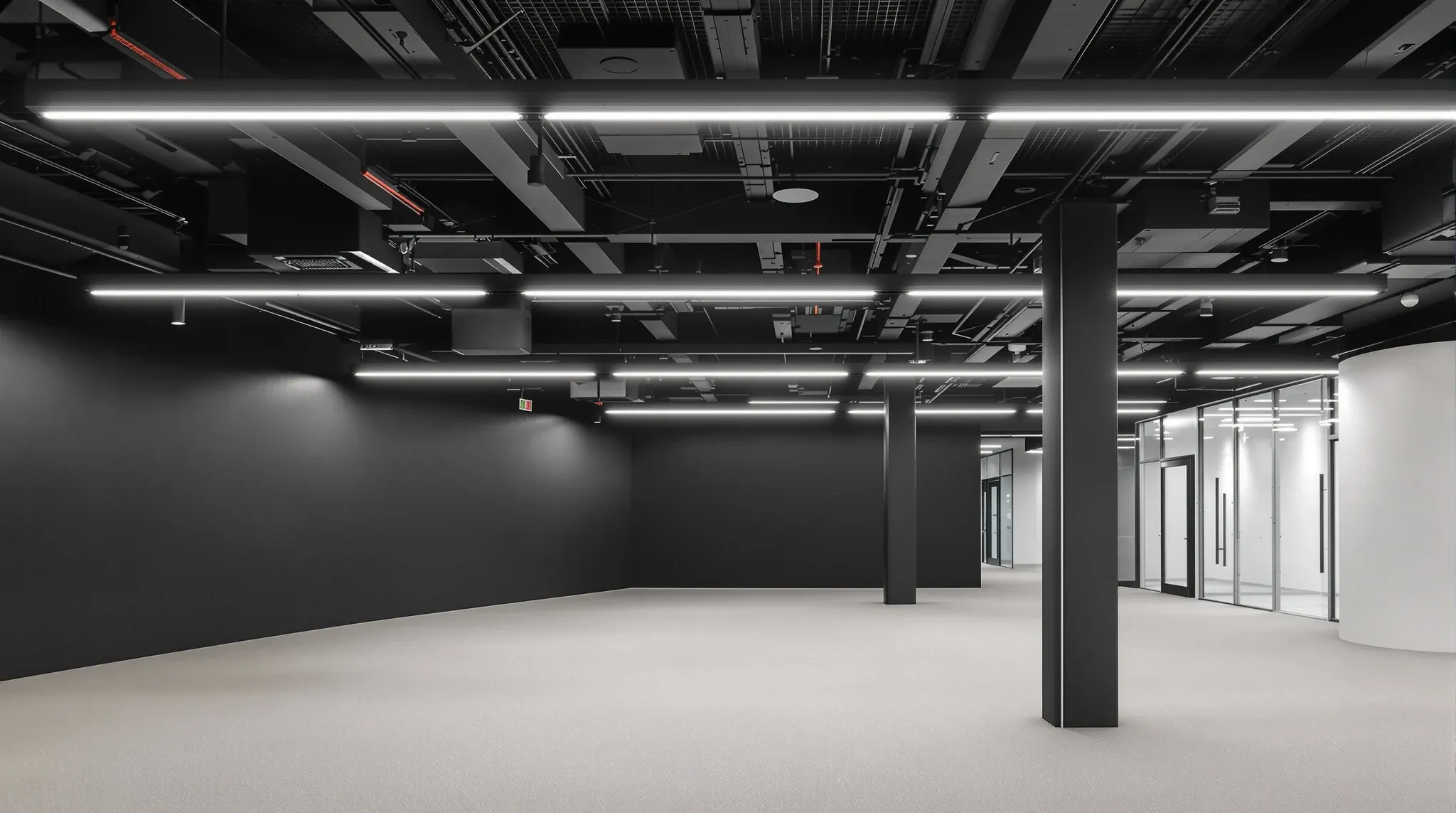 Empty finished office with black painted exposed ceiling, suspended linear lights, acoustic baffles
