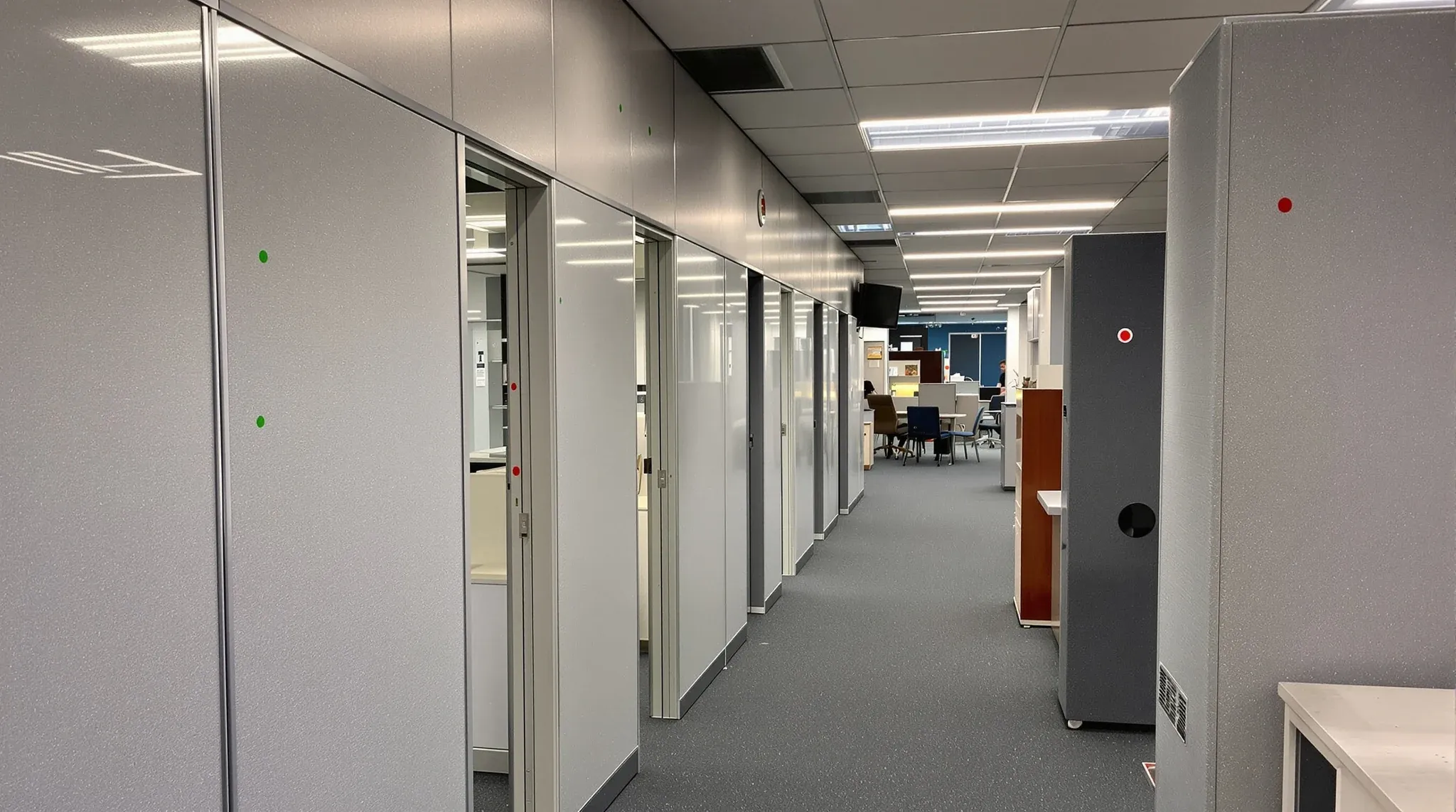 Green and red dot stickers marking walls, doors and furniture to keep or remove in an old office
