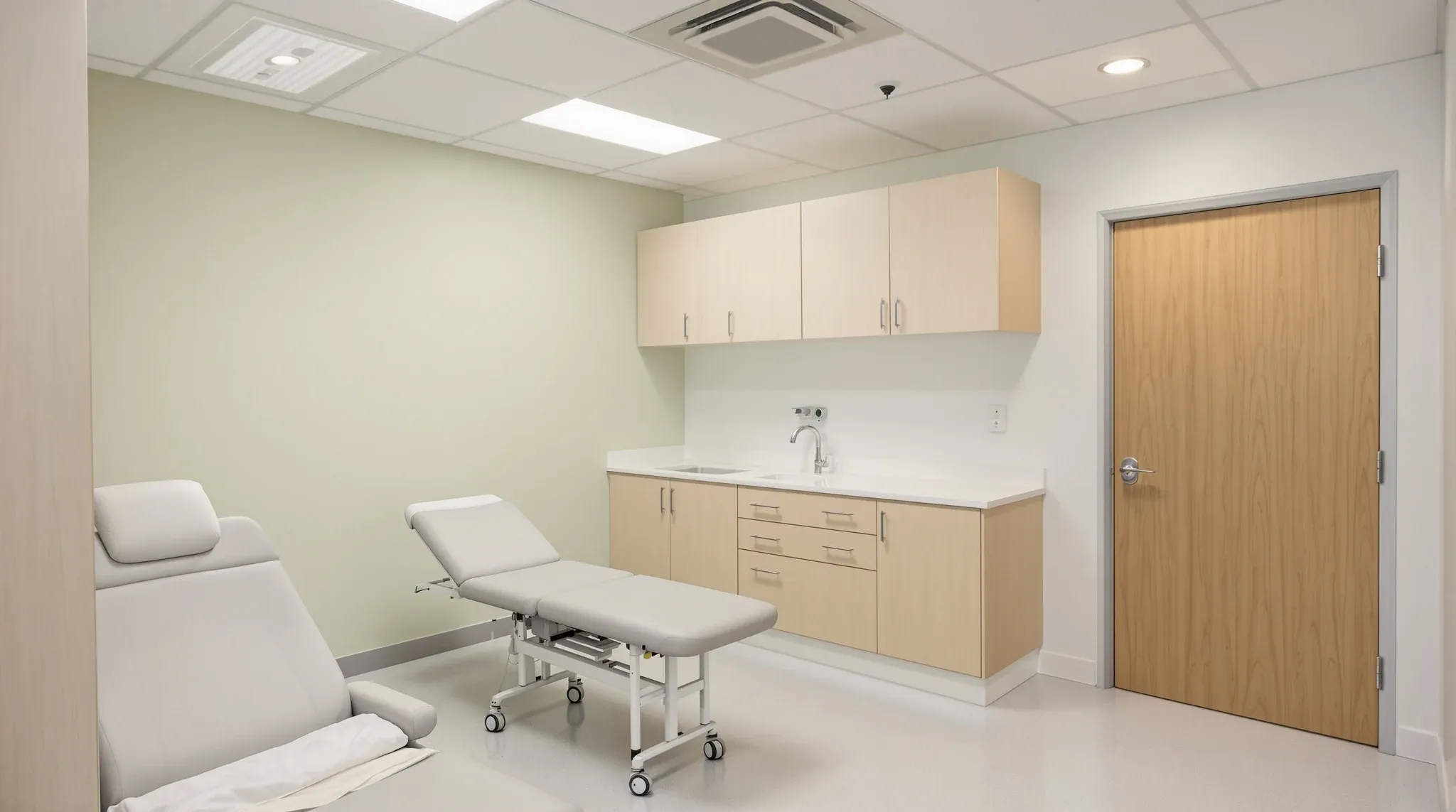 A finished medical consulting room with an examination couch and built-in joinery