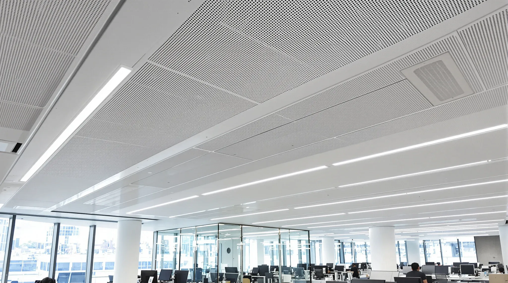 Open-plan office with long active chilled beams set into the ceiling above the workstations