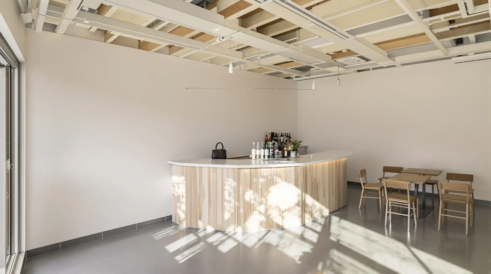Empty finished small cafe interior with counter edge, timber tables, exposed ceiling, no signage