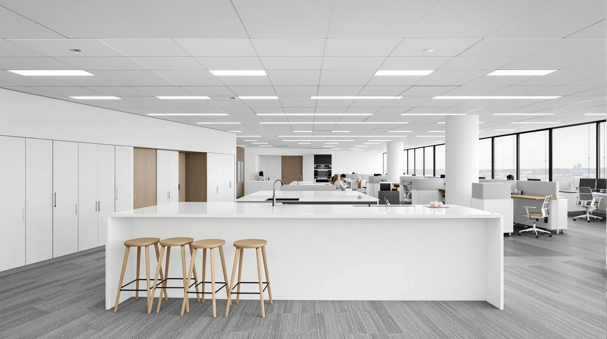 A practical office floor in a newer tower with a kitchen island, four spaced stools and workstations beyond