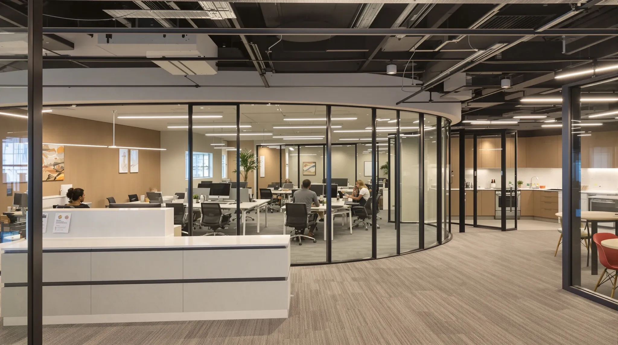 A finished practical open-plan office showing desking, a meeting room and a kitchenette