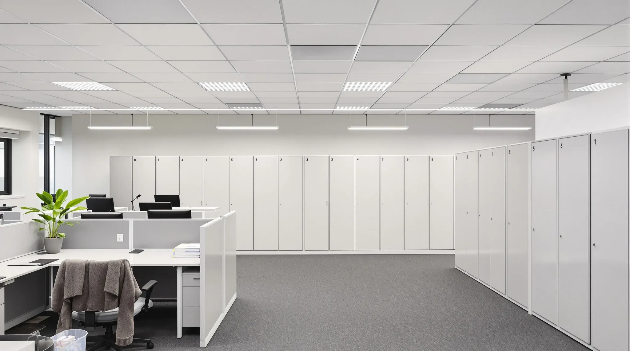 Personalised assigned desks in front of clear shared desks and a wall of lockers in an ordinary office