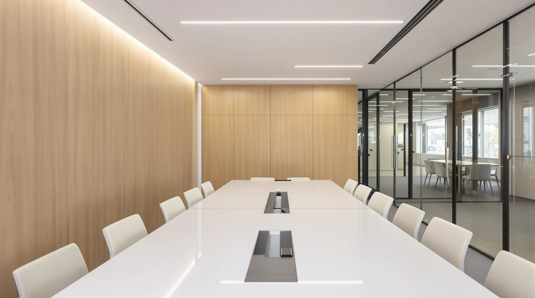 Empty finished boardroom with long table, wall screen off, acoustic timber wall, glass wall to corridor, no logos