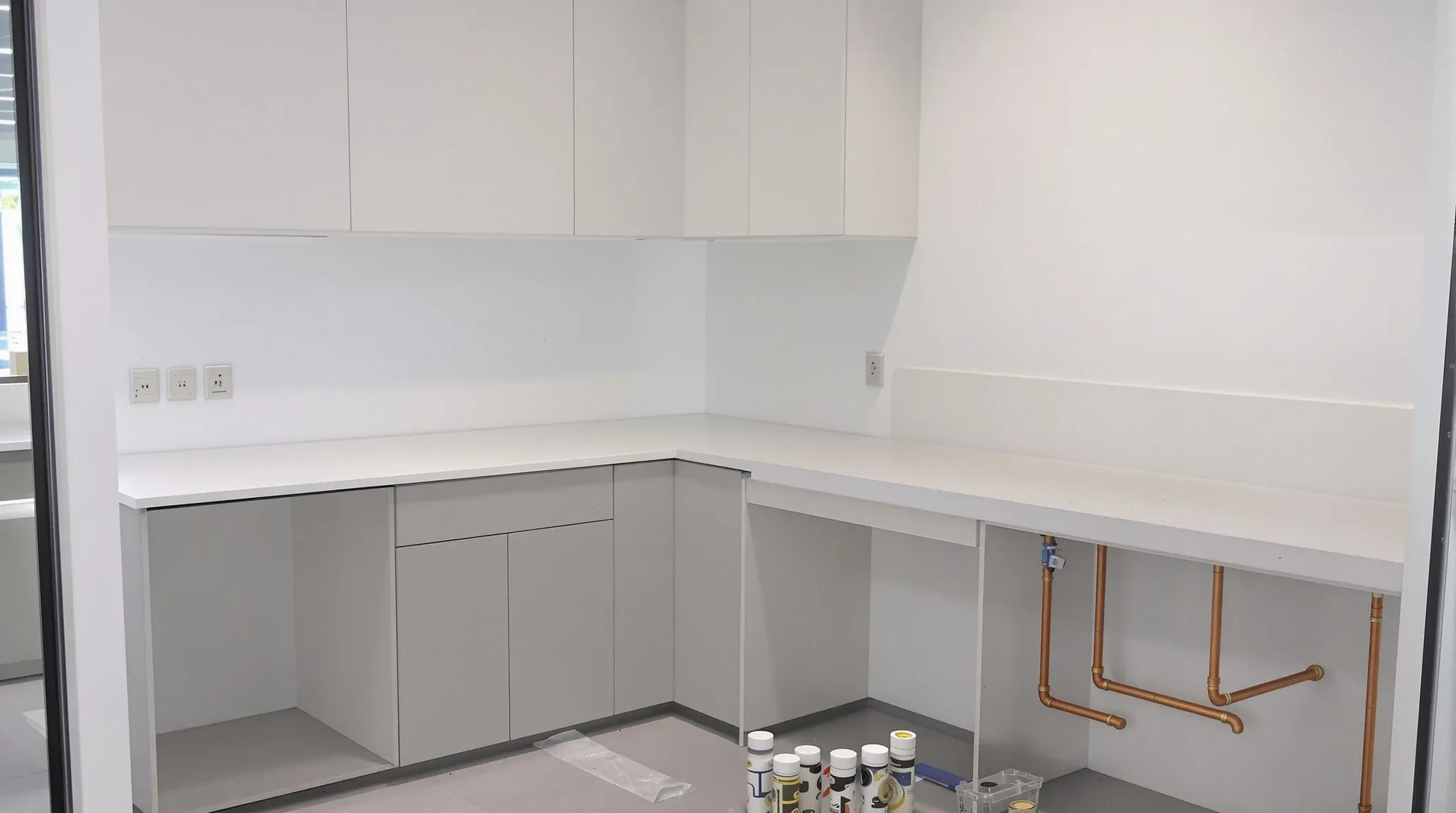 An office kitchenette mid-install with the benchtop leaning against the wall, unfitted