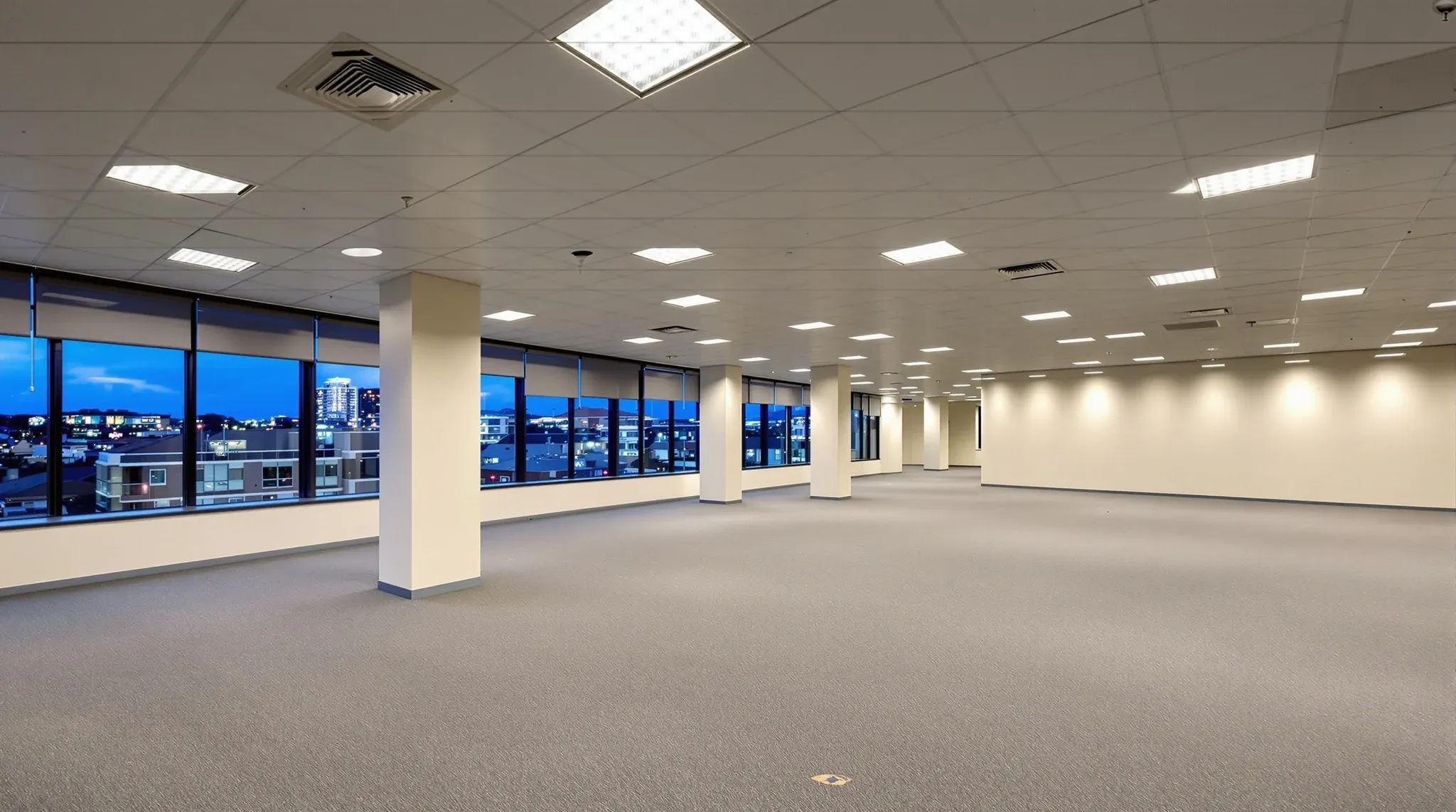 An empty office floor with ceiling, lights and carpet installed, ready for a tenant fitout