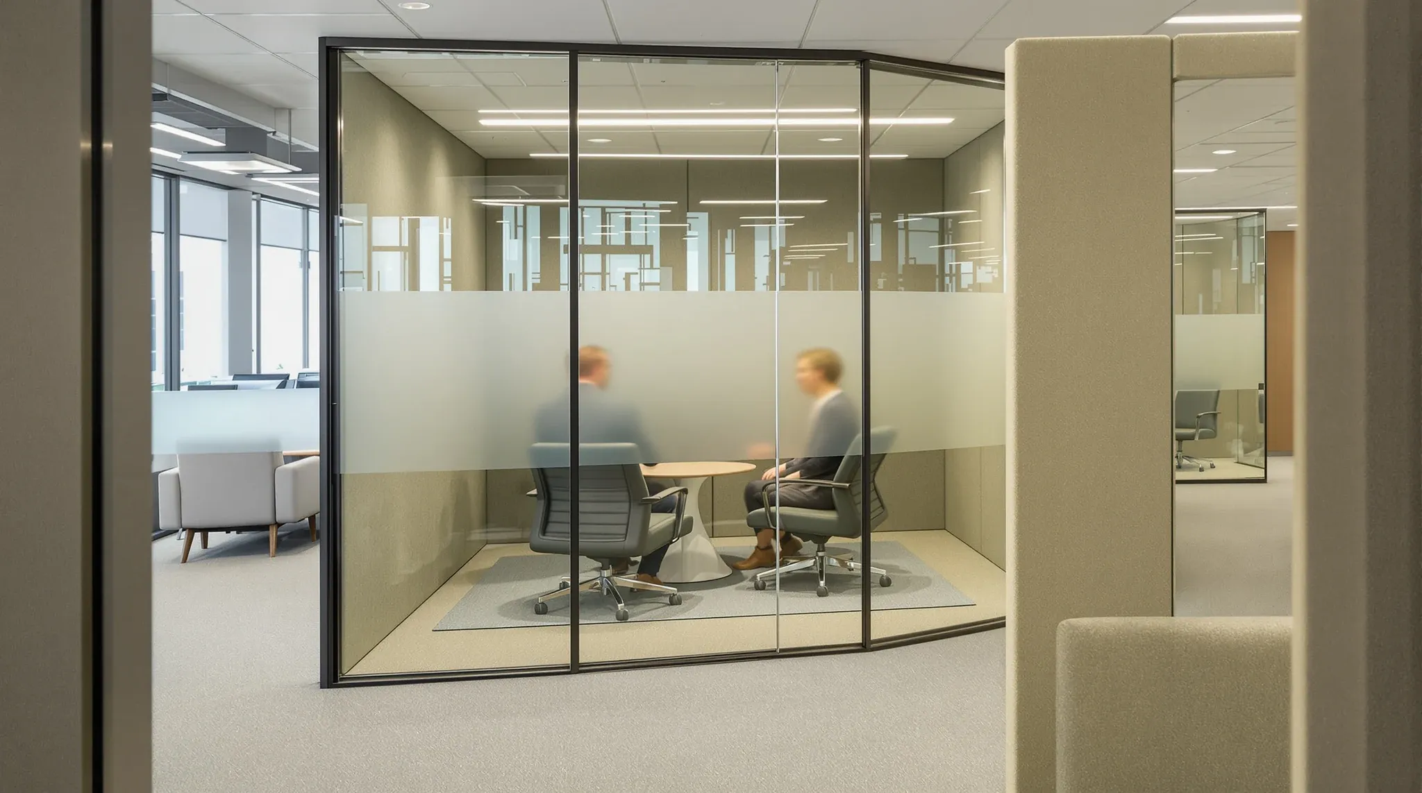 A glass meeting room with fabric acoustic panels and a rug, two people blurred inside
