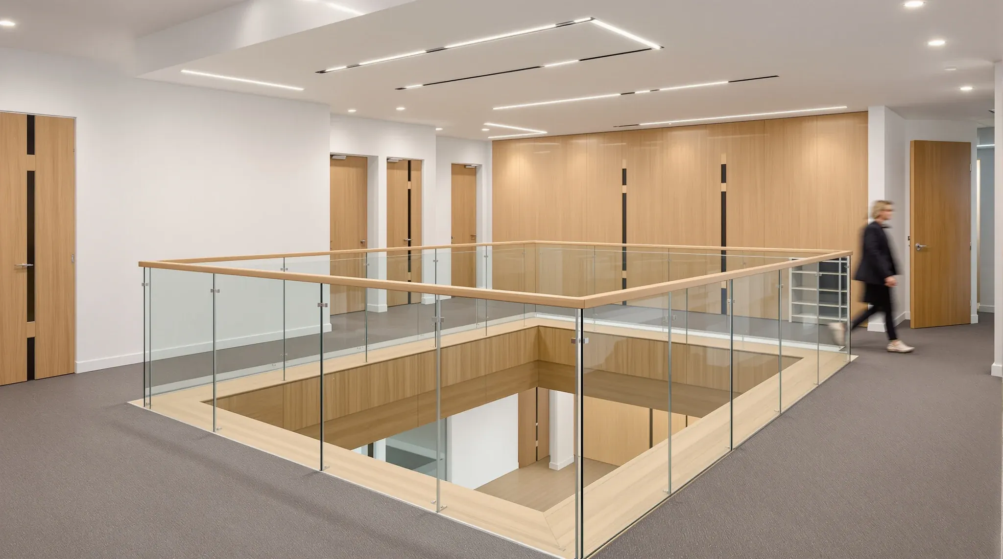 The glass-edged opening of an interconnecting stair on the upper floor of a law firm office