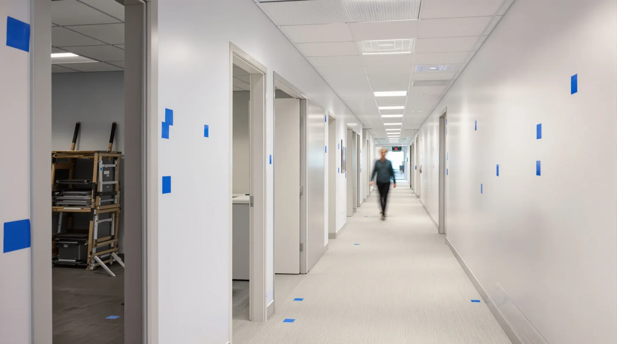 A finished, empty office before move-in with small squares of tape marking paint touch-ups