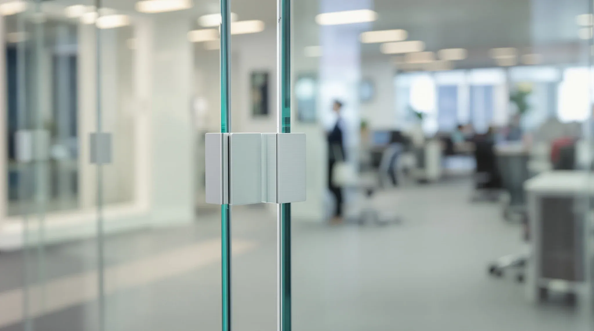 The corner post of a glass office partition with two panes meeting cleanly