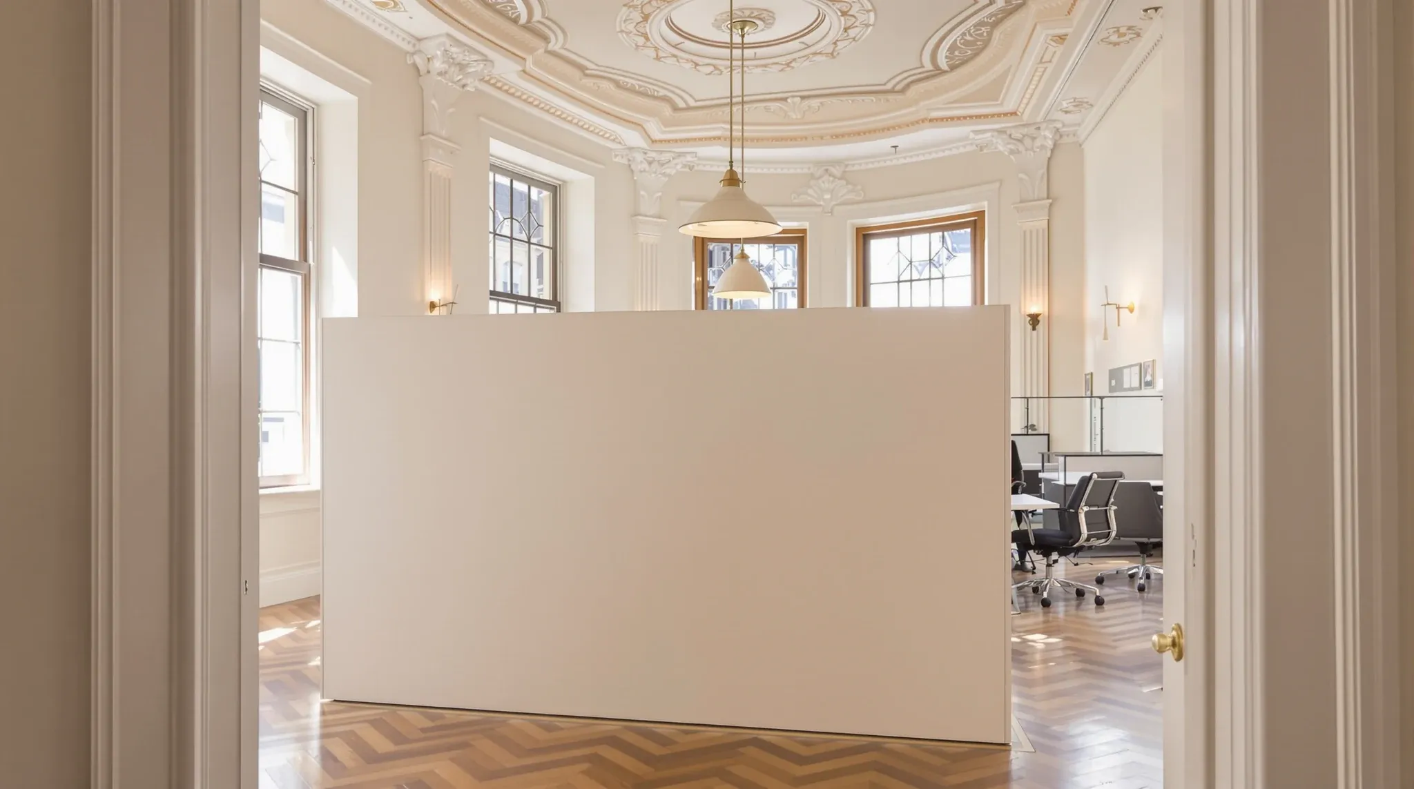 An office in an older Victorian building with high ceilings, cornices and a freestanding partition