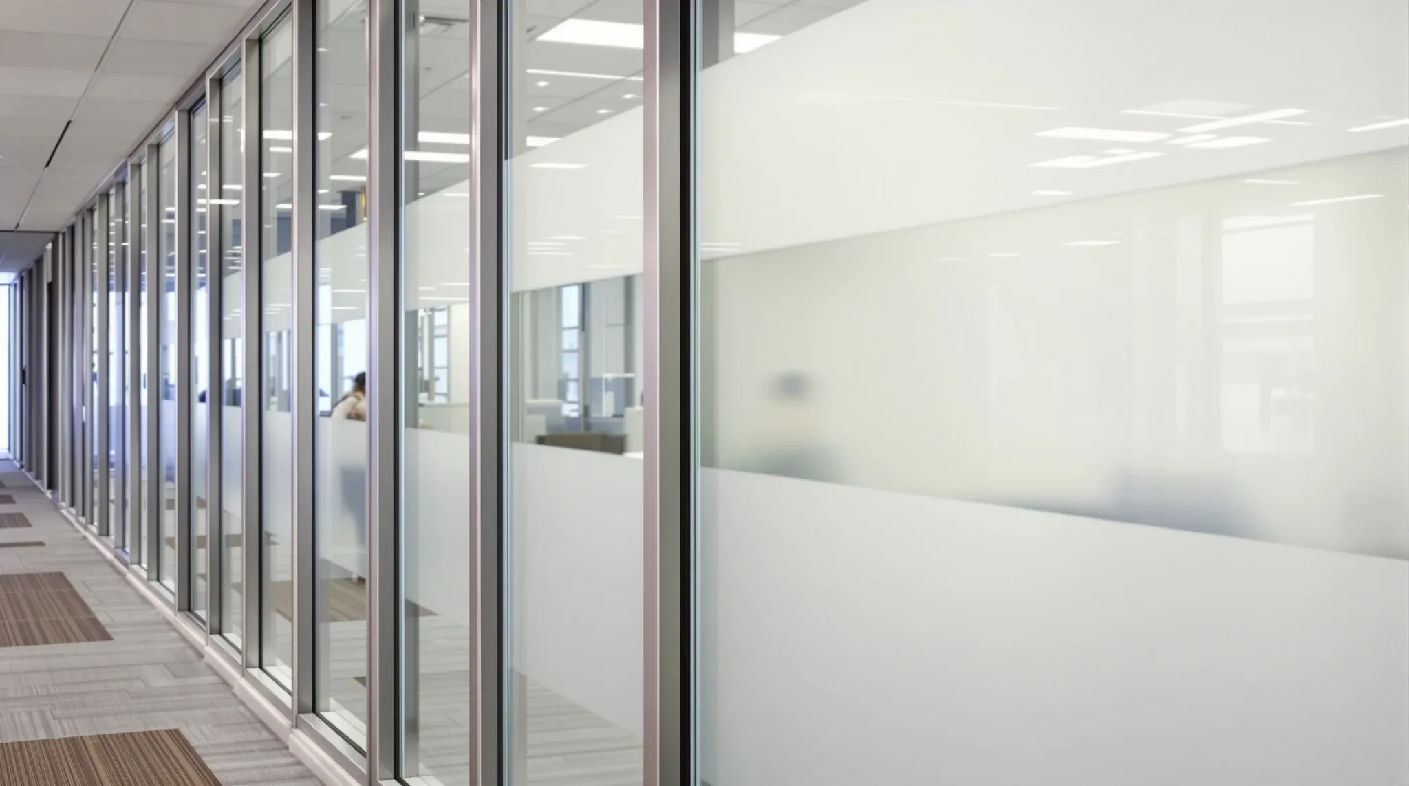 An older aluminium office partition frame fitted with new satin frosted glass with a clear band