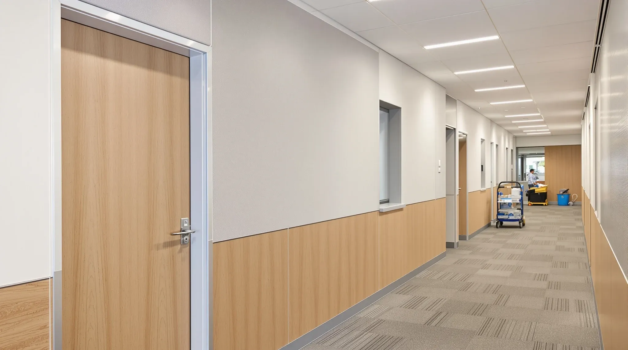 Office corridor with laminate-faced partition walls at lower height and painted plasterboard above
