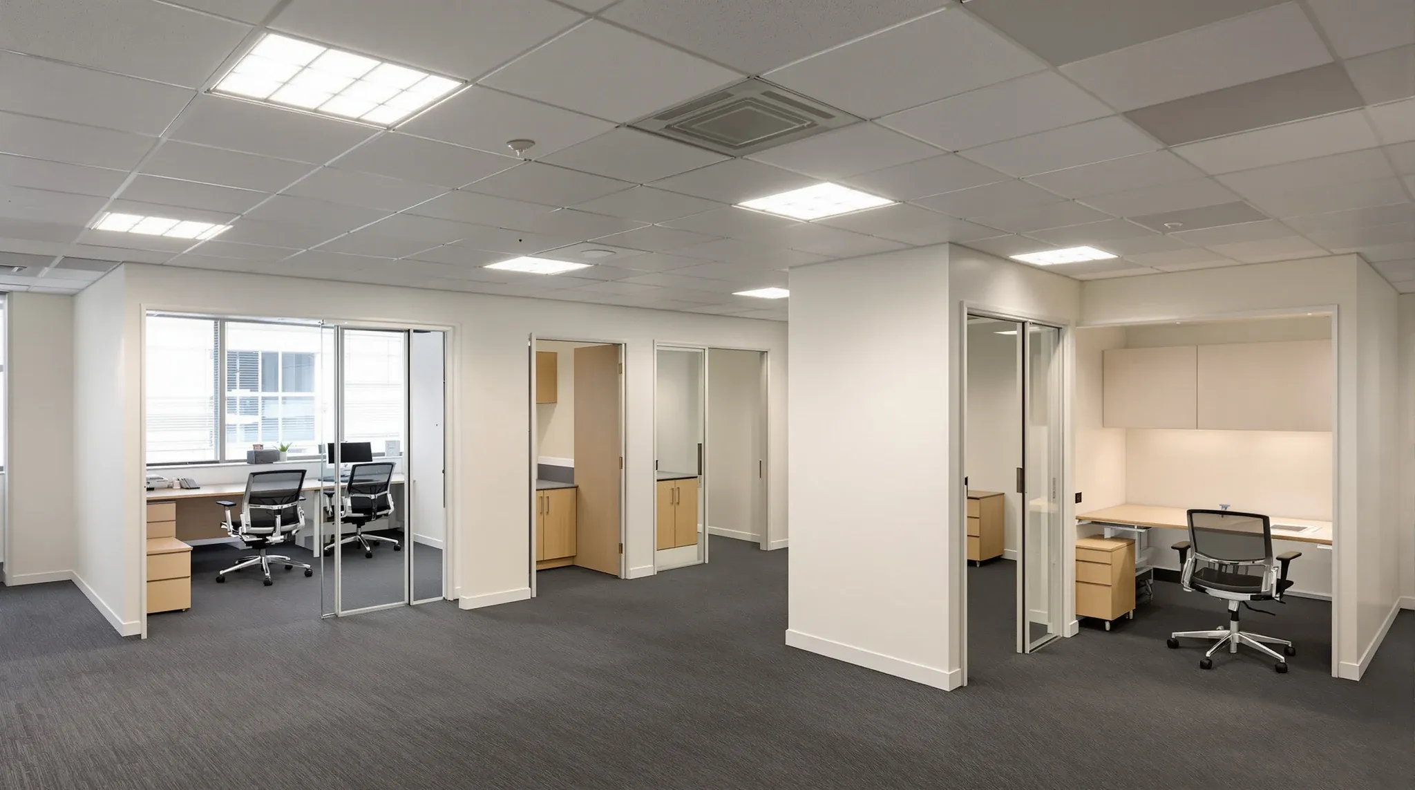 A new office fitout beneath an older retained suspended ceiling with dated square light panels