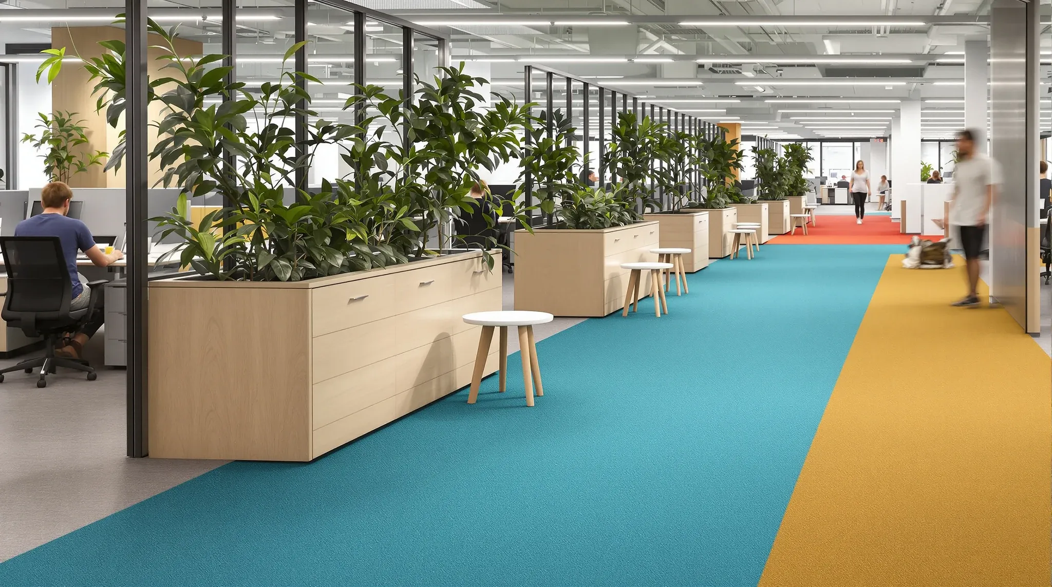 An open office floor zoned into team areas by carpet colour and low storage