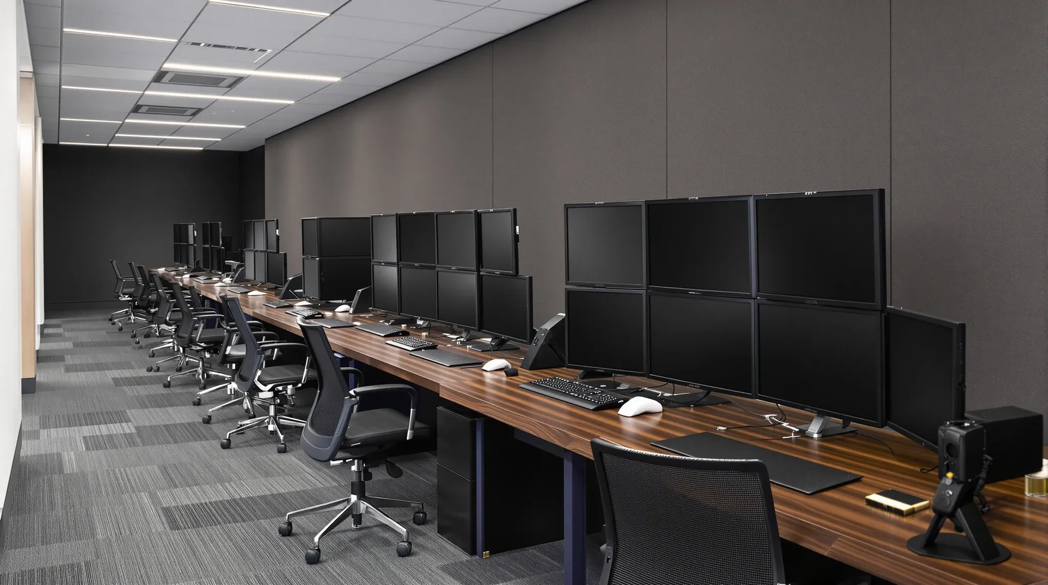 A long dealing desk with a block of four dark screens at every seat after the market has closed