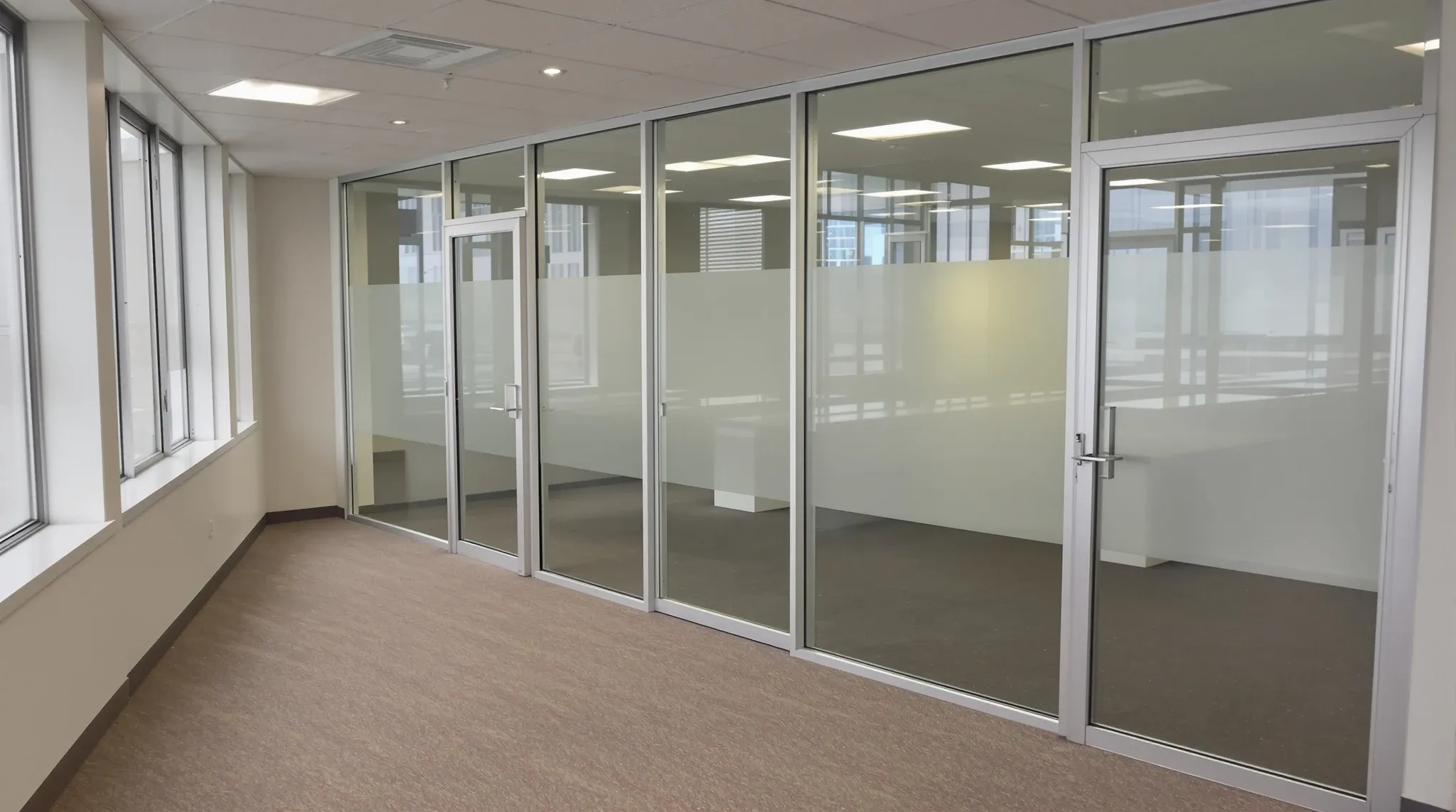 Dated silver-framed glass offices left in an empty office tenancy between leases