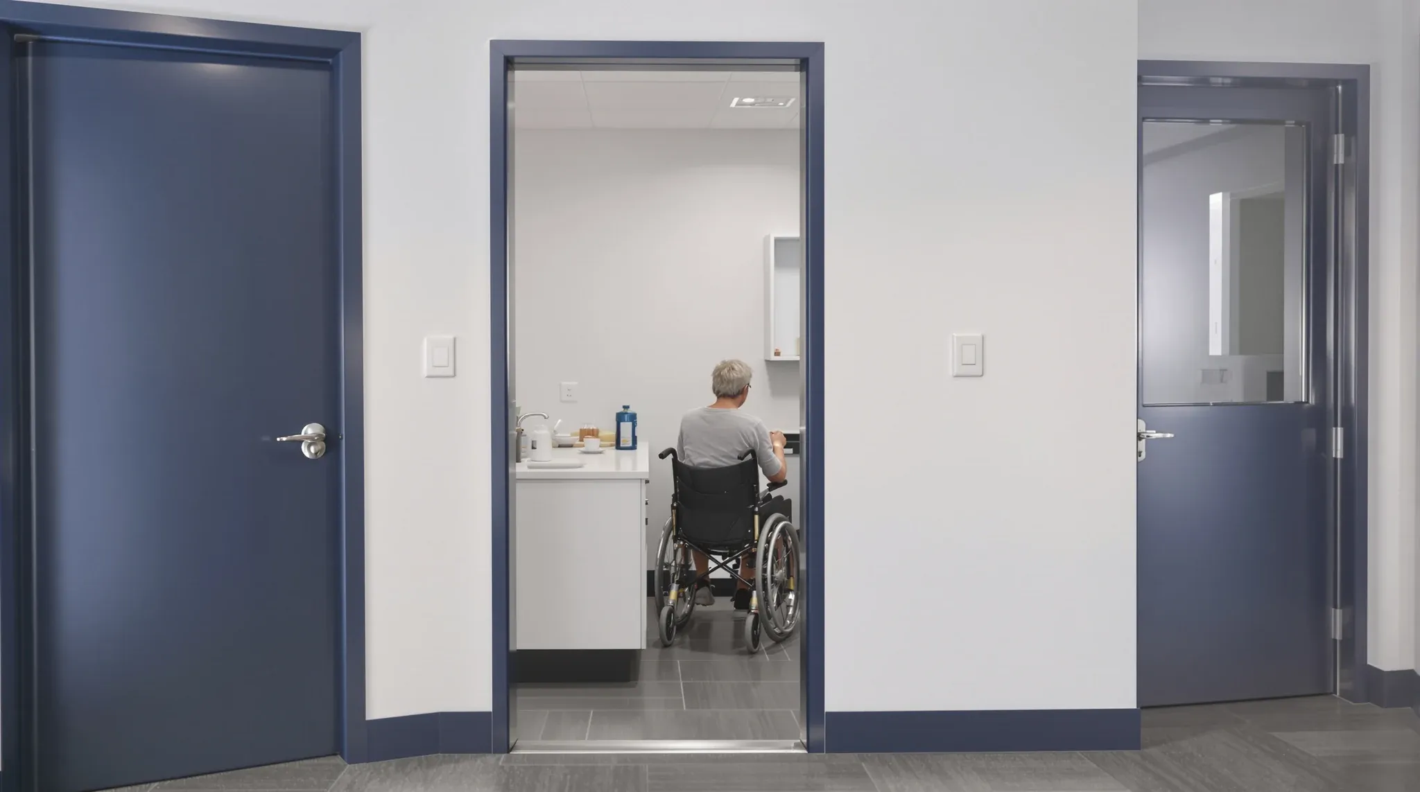 An accessible office kitchenette with a lowered bench and a wide door with an automatic opener