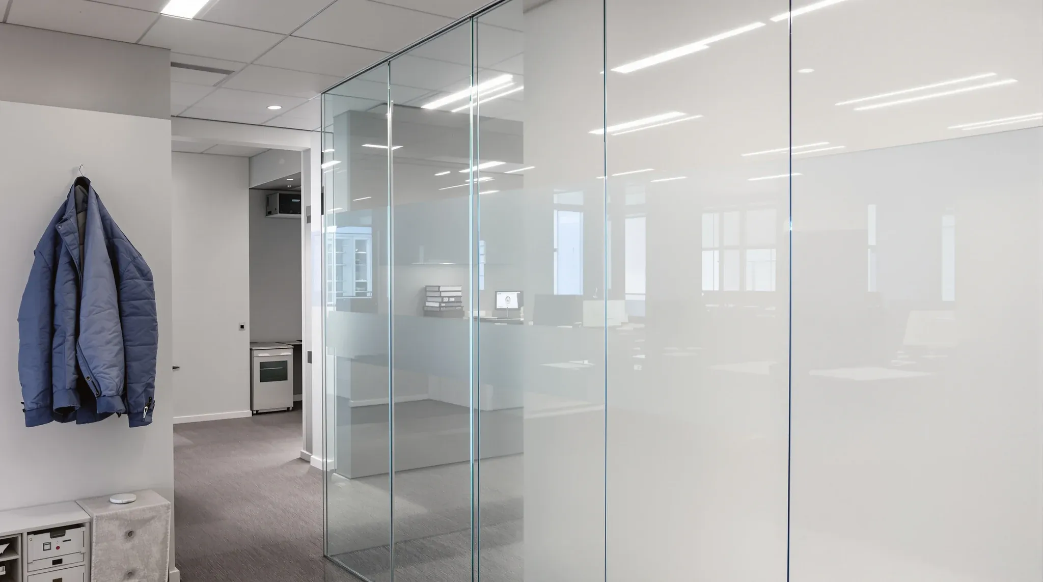 A clear low iron glass partition edge in a lived in open plan office