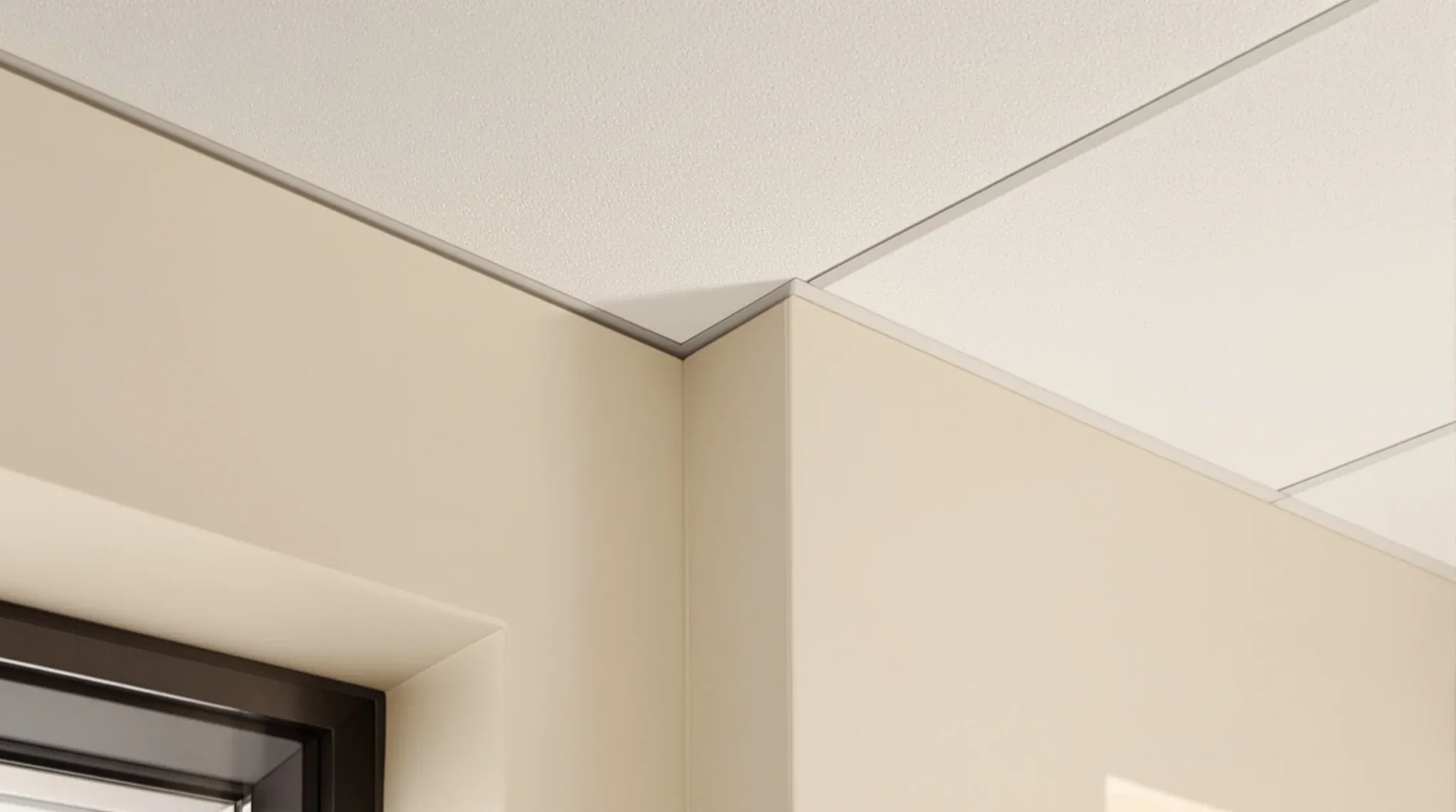 A suspended office ceiling meeting an old rendered masonry wall with a neat shadowline trim