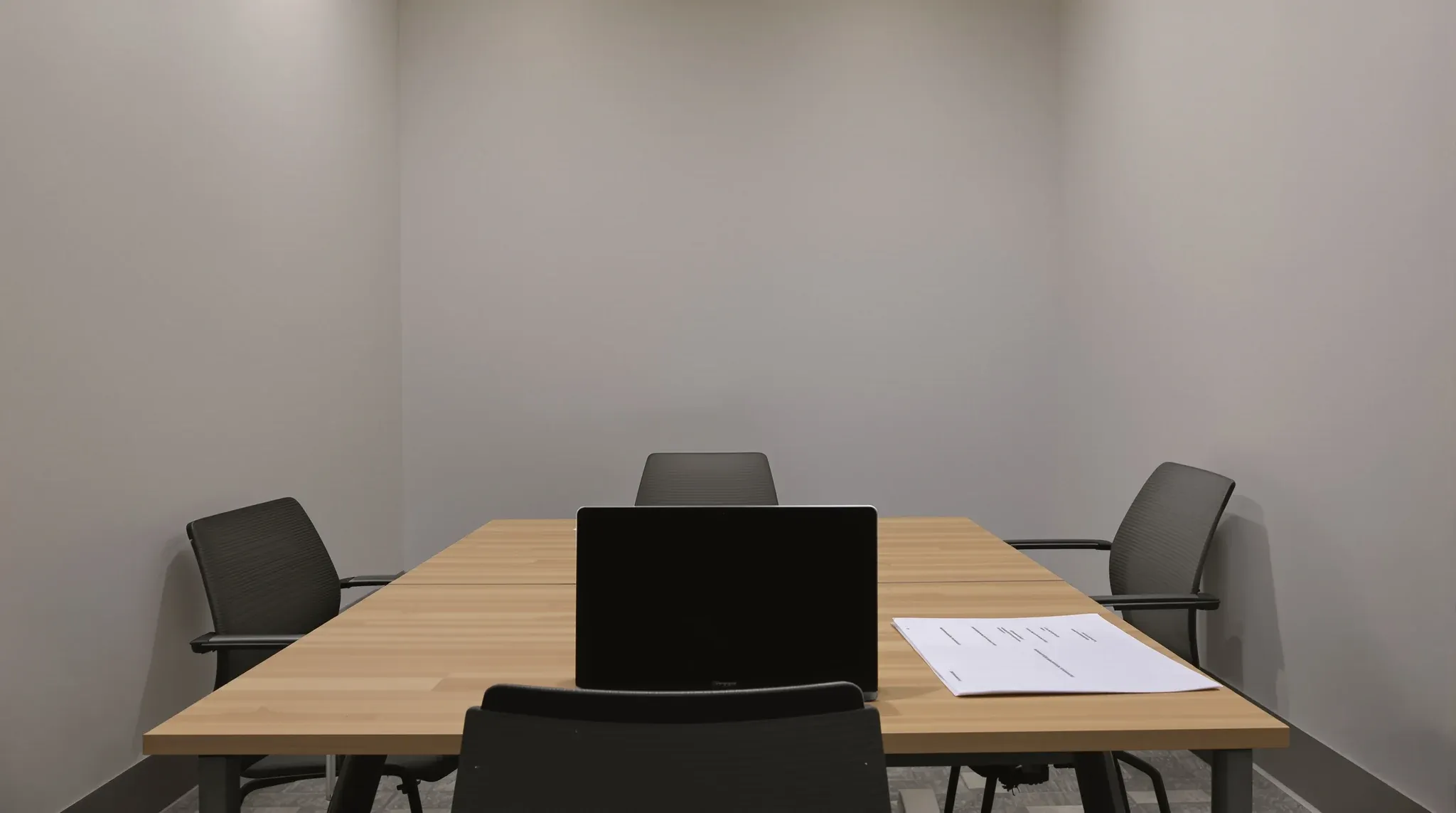 A meeting room table set up for reviewing a fit-out quote, papers face down
