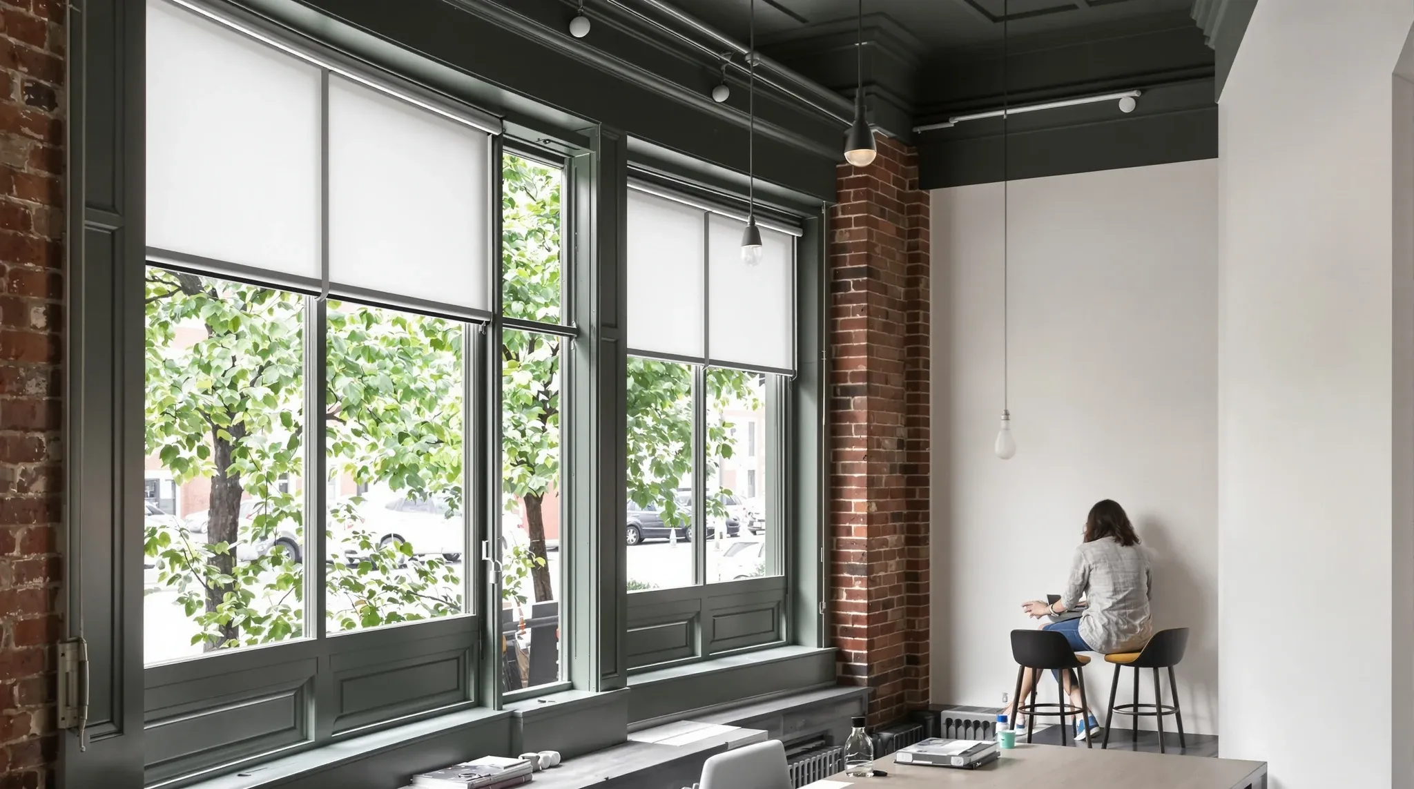 A former corner shop converted into a small office, with timber floors and shopfront windows onto a tree