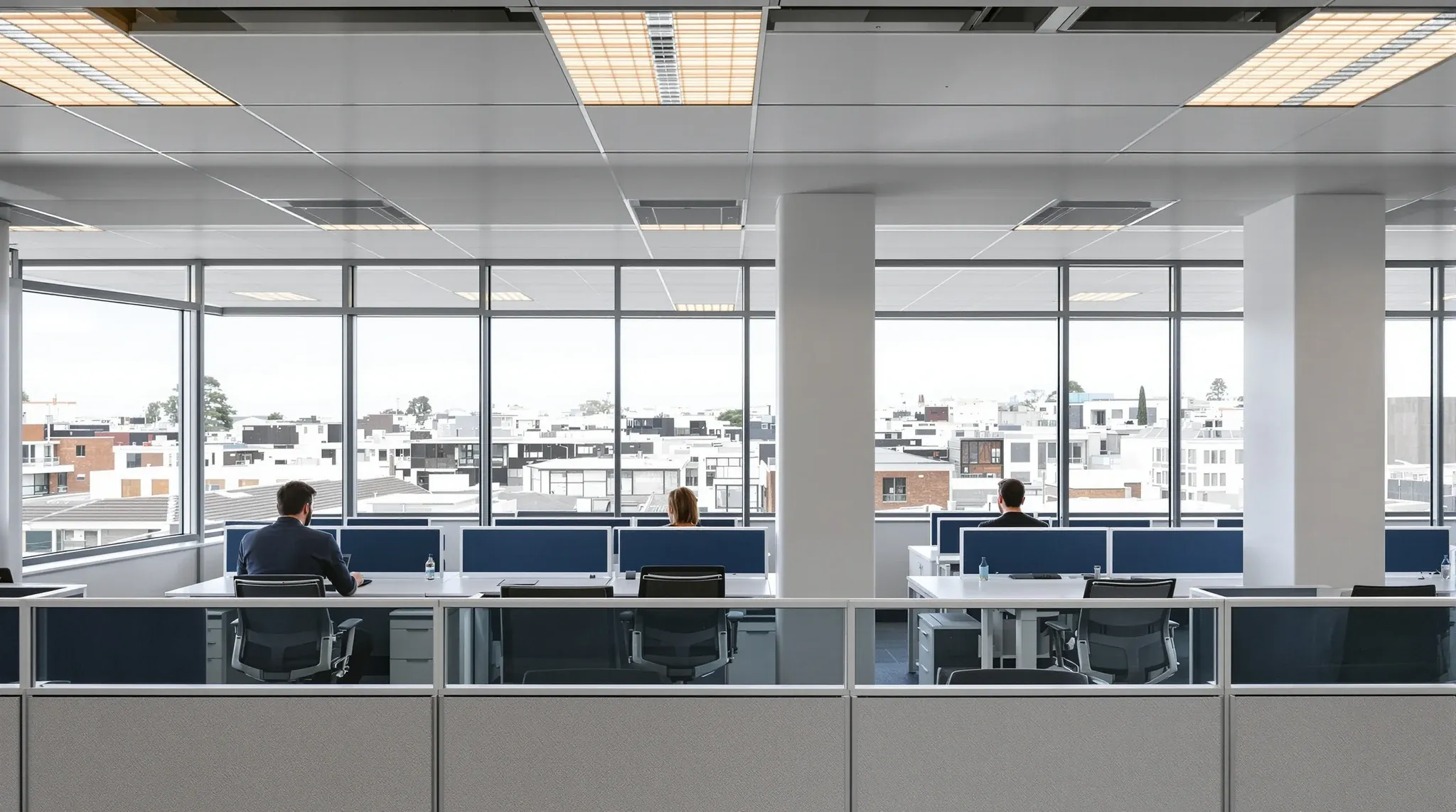 A professional services office in a regional mid-rise building with morning light along the workstations