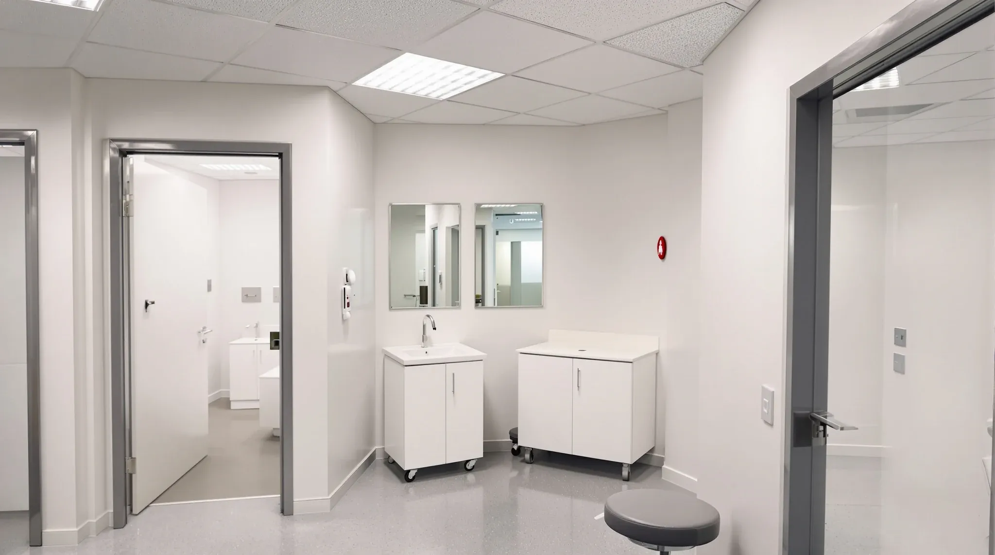 Empty finished small room with examination couch, hand basin, cabinet with no labels