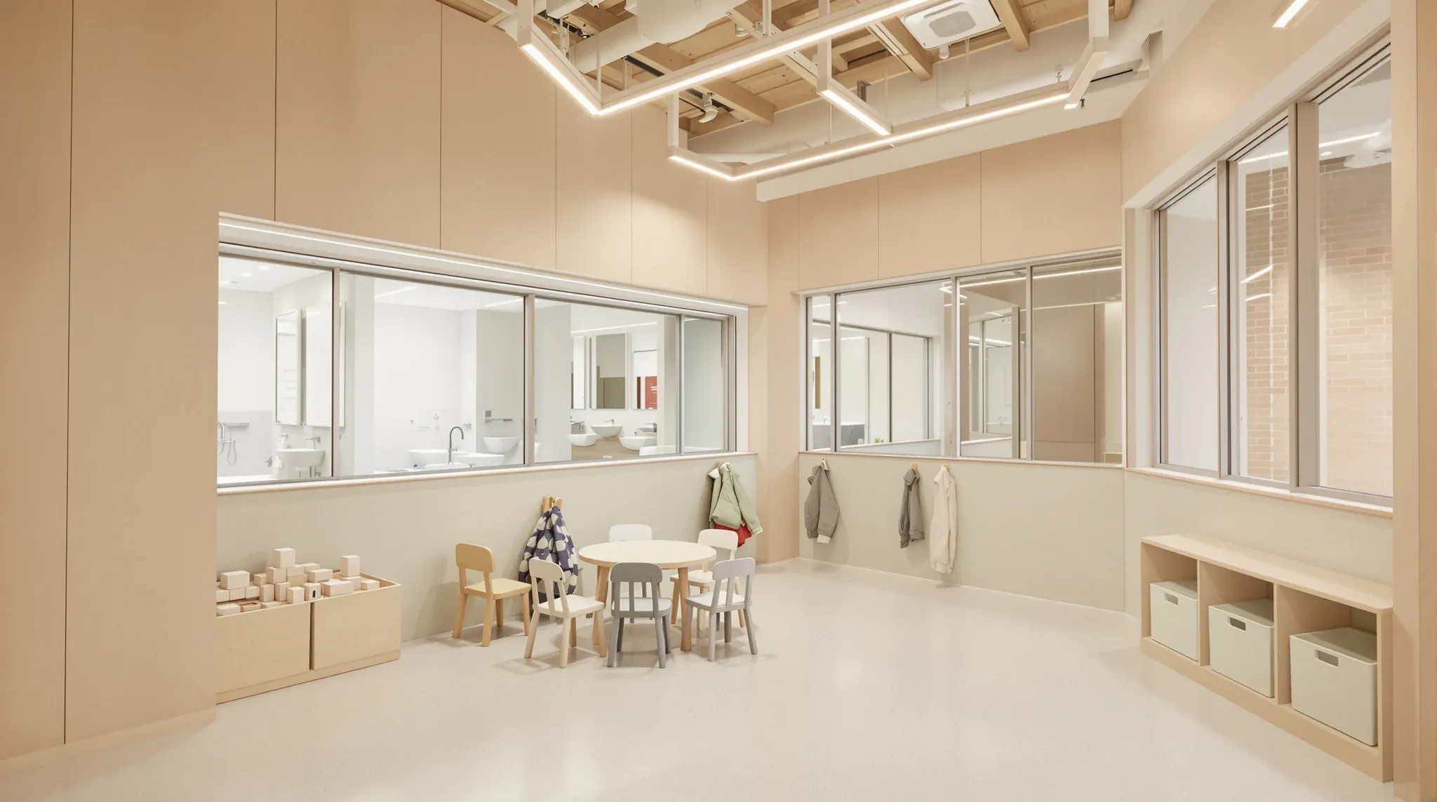 Finished childcare playroom in a converted commercial tenancy with a glazed viewing panel into a children's bathroom